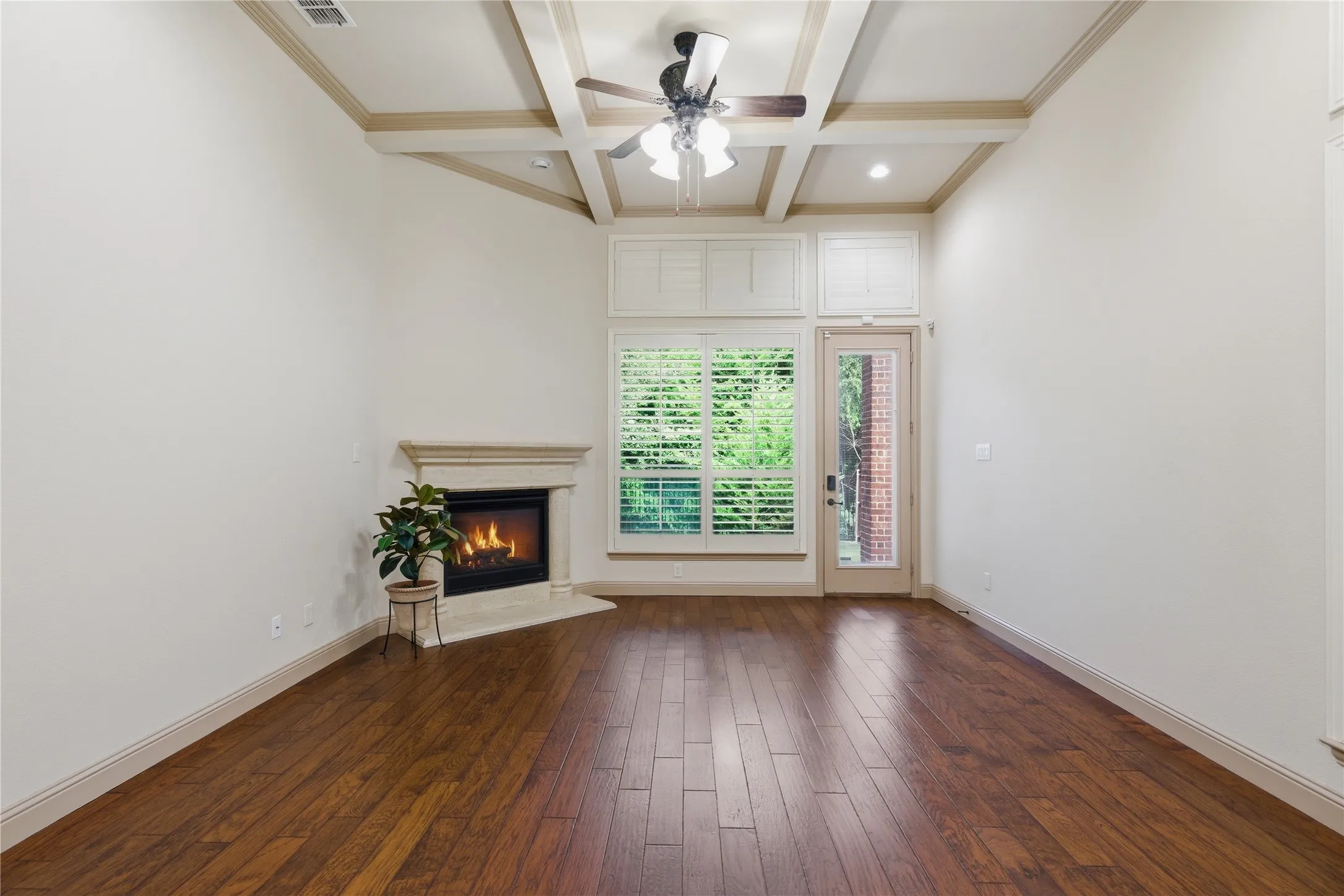 Gas Fireplace, Plantation Shutters and view of Wooded Area