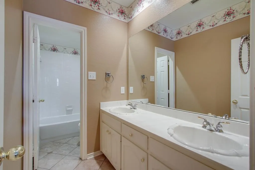 Upstairs. Double vanity with integrated sinks, chrome faucets, and white cabinetry