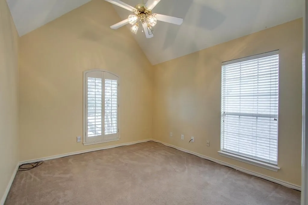 Upstairs. Carpeted room featuring a vaulted ceiling and a ceiling fan with integrated lighting