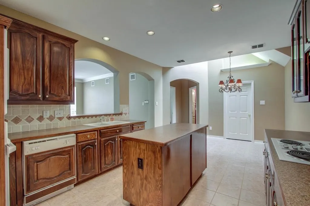 Kitchen featuring wood cabinetry, a central island, and tile flooring