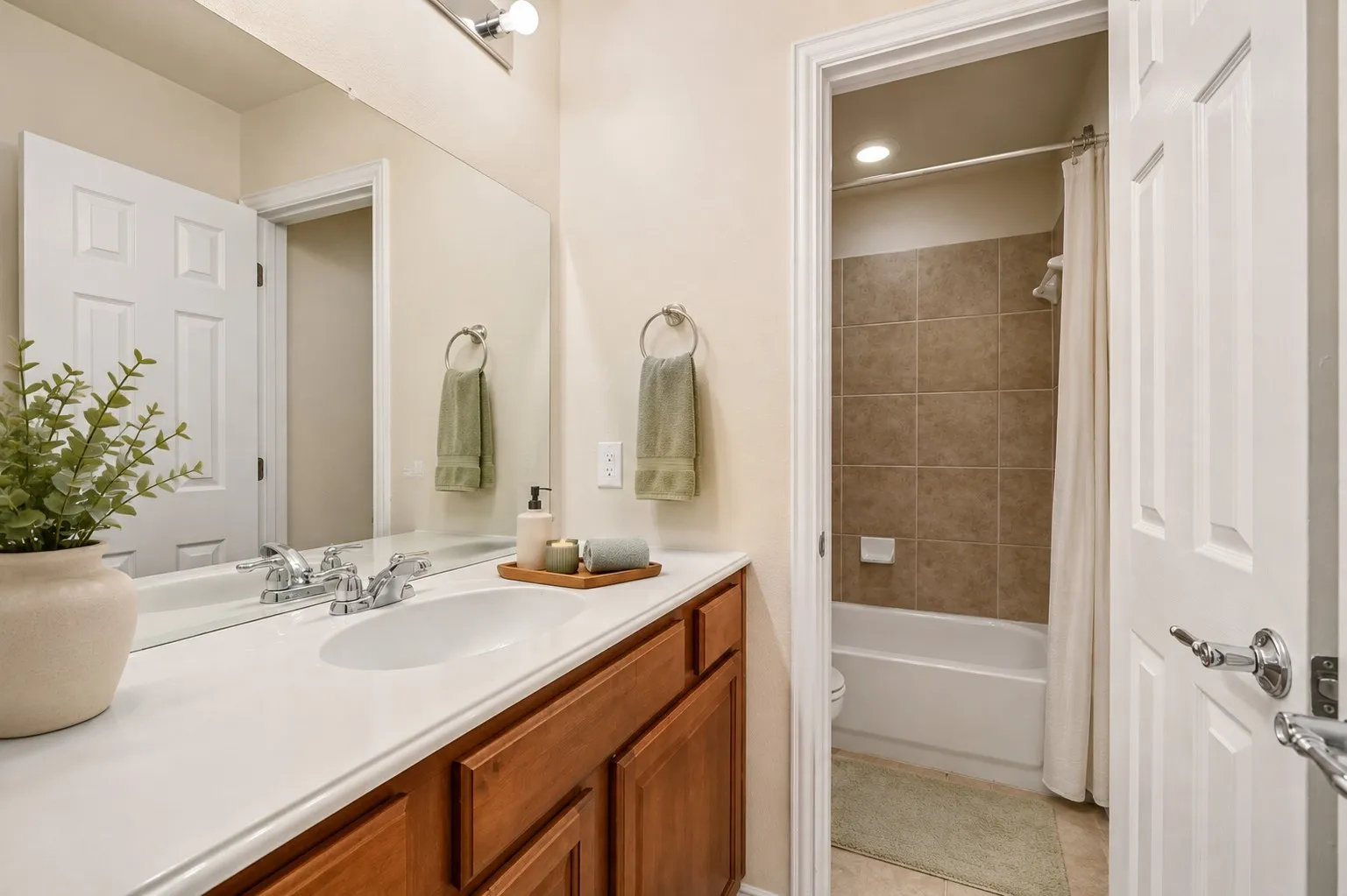 Bathroom featuring a wood-finish vanity with a white countertop and chrome​​‌​​​​‌​​‌‌​‌‌​​​‌‌​‌​‌​‌​​​‌​​ fixtures