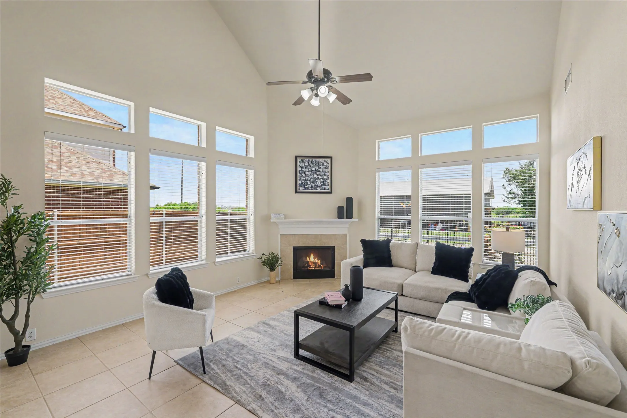 Bright living area featuring a vaulted ceiling and tile flooring