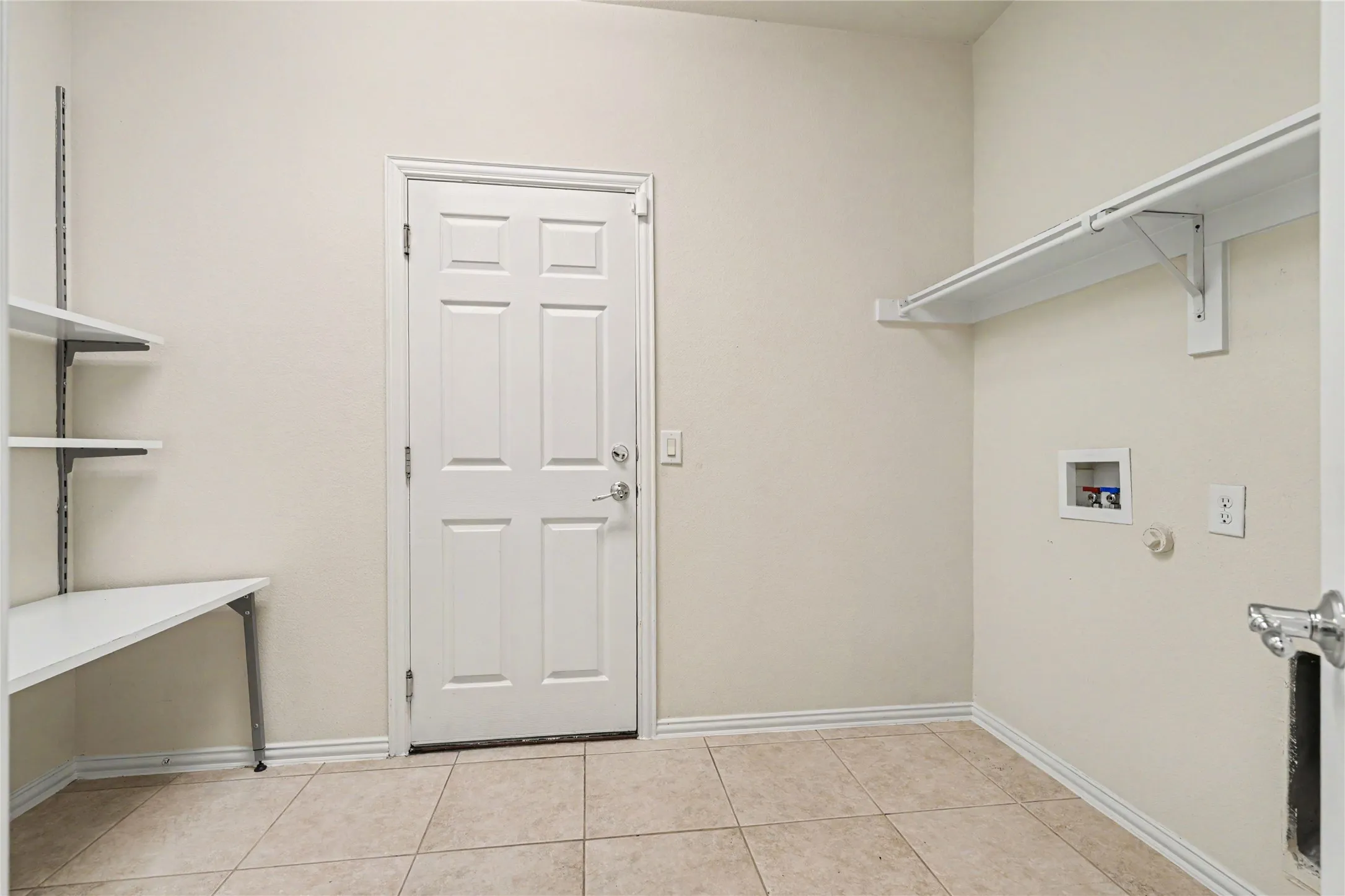 Utility room with neutral wall paint and tile flooring