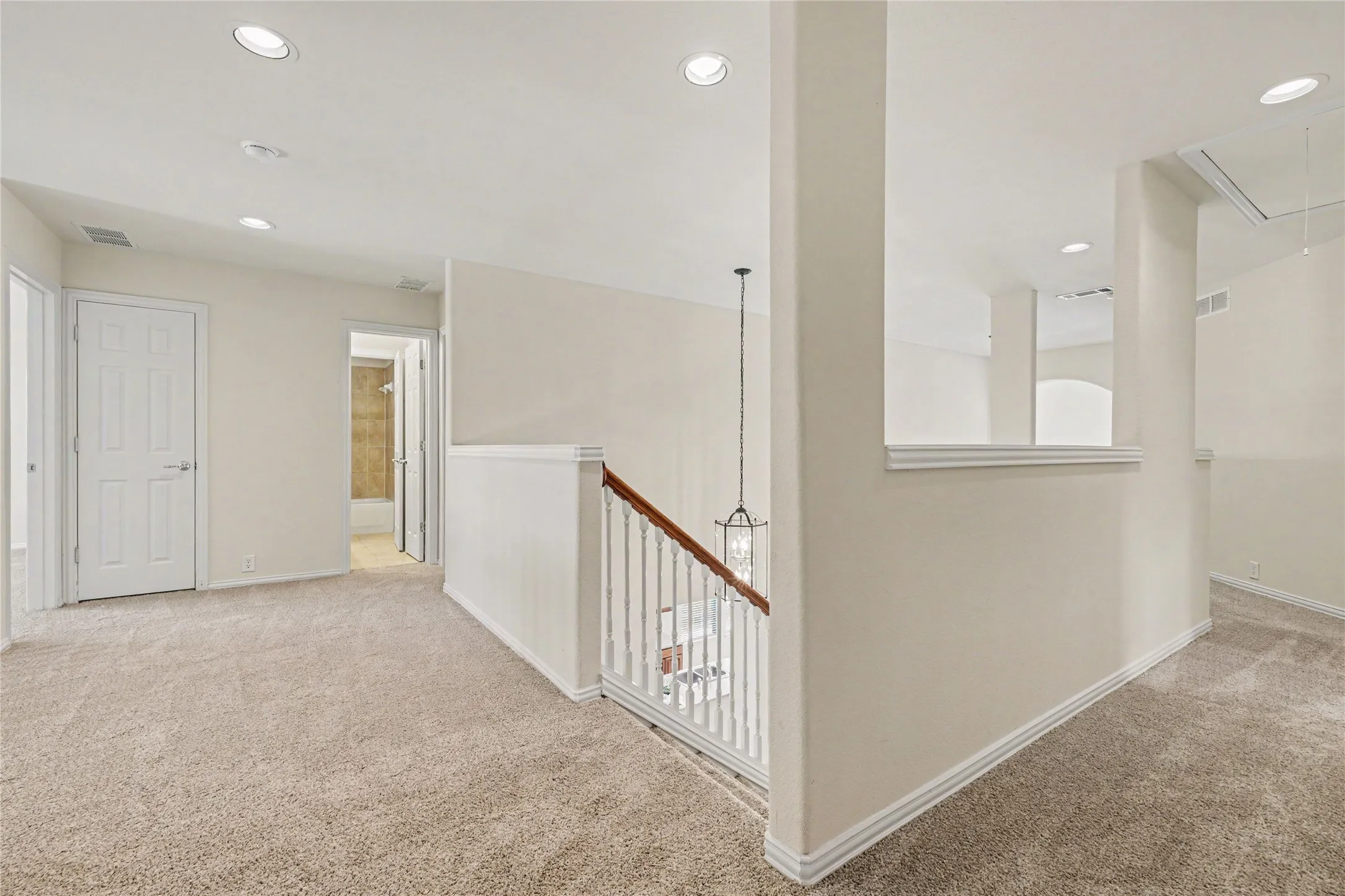 Upper-level landing featuring neutral carpeting and recessed lighting
