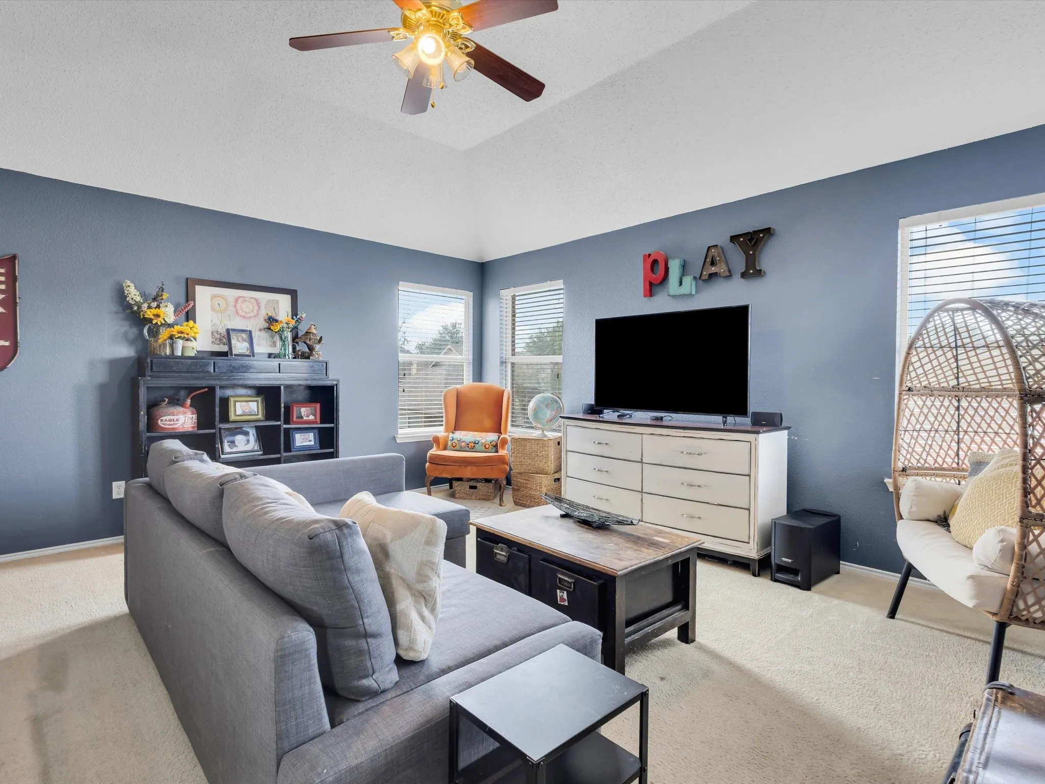 Spacious room featuring a vaulted ceiling and a ceiling fan with integrated lighting