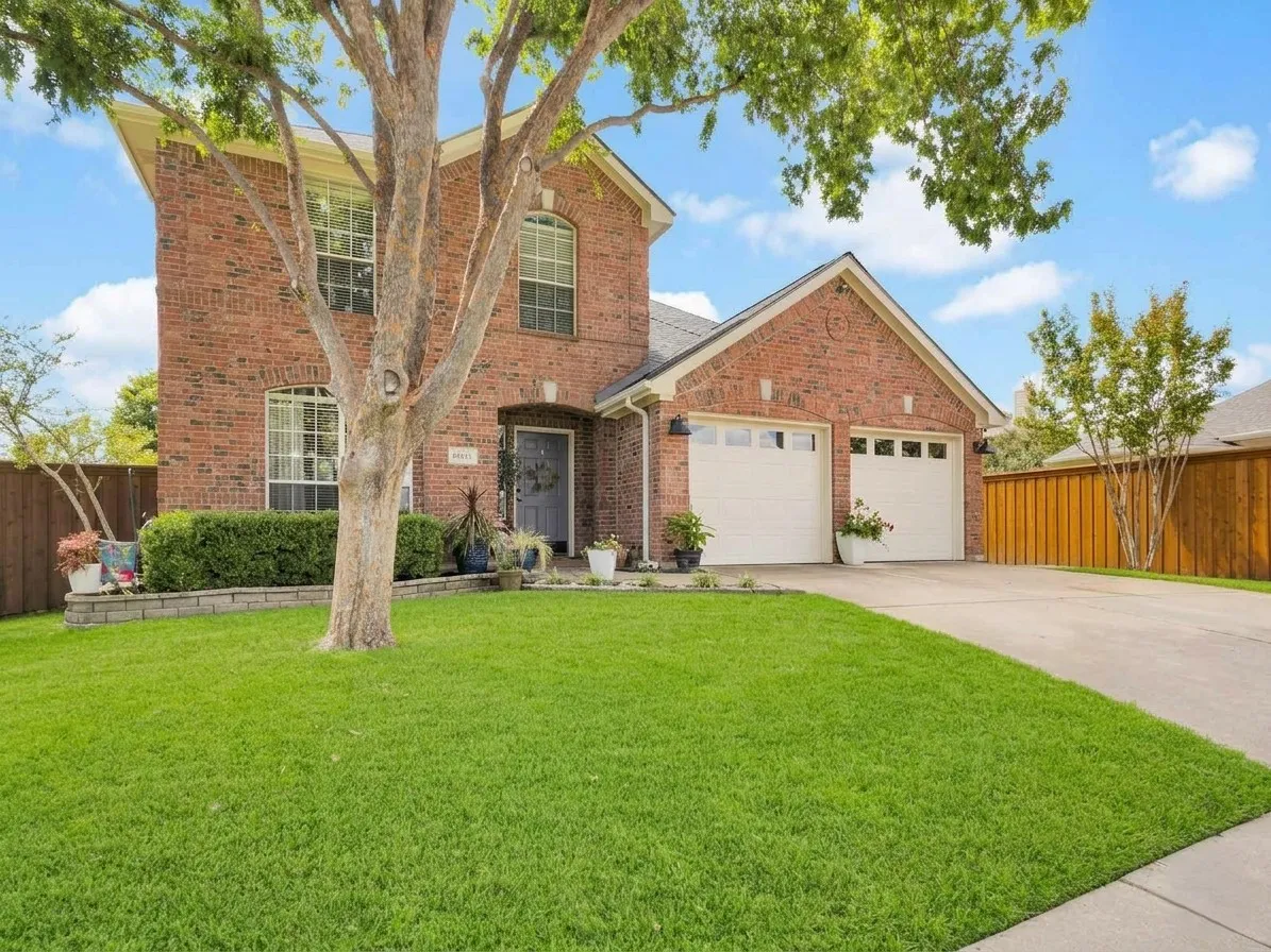 Brick exterior featuring arched windows and a two-car garage