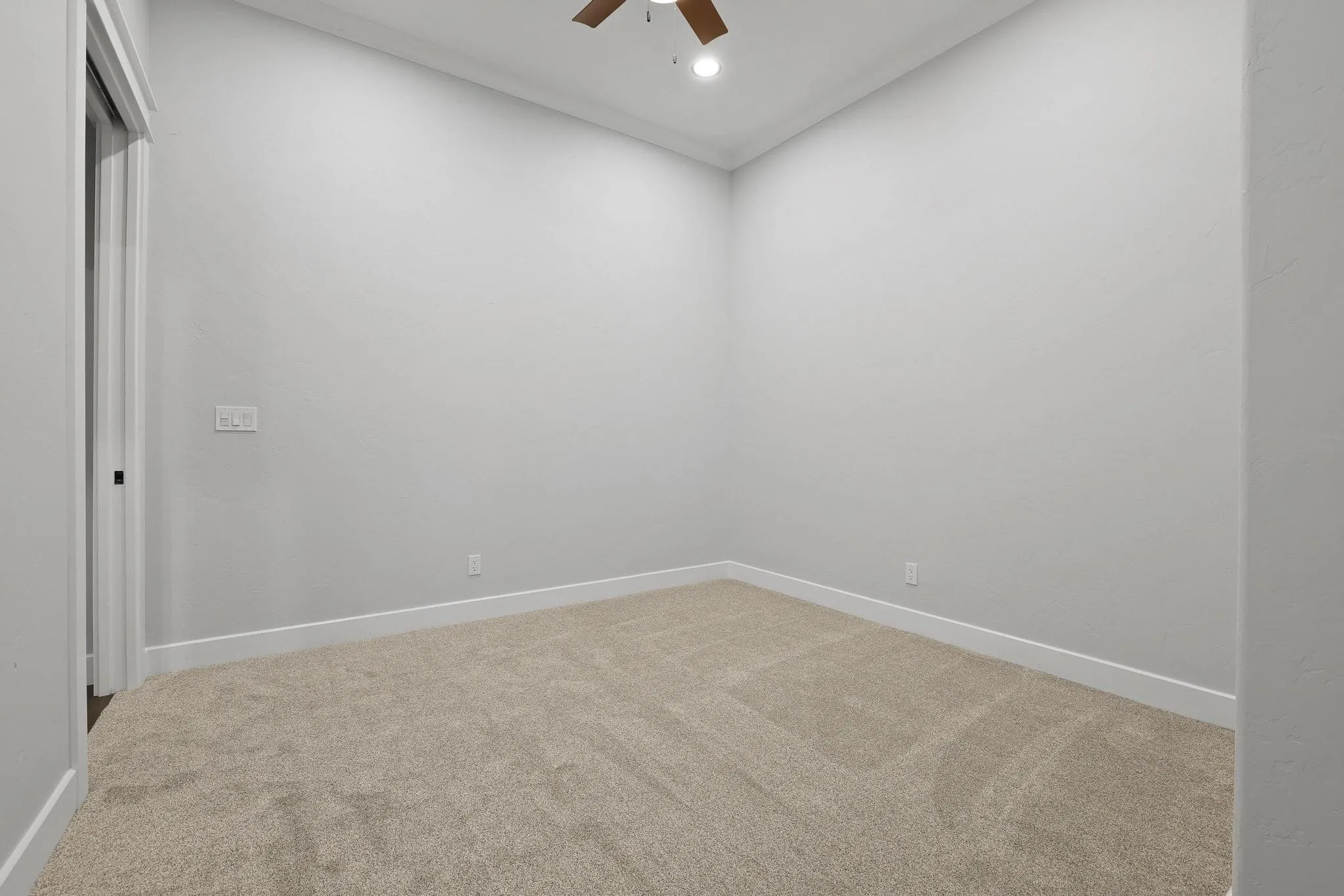 Carpeted interior space featuring neutral wall tones and white baseboards