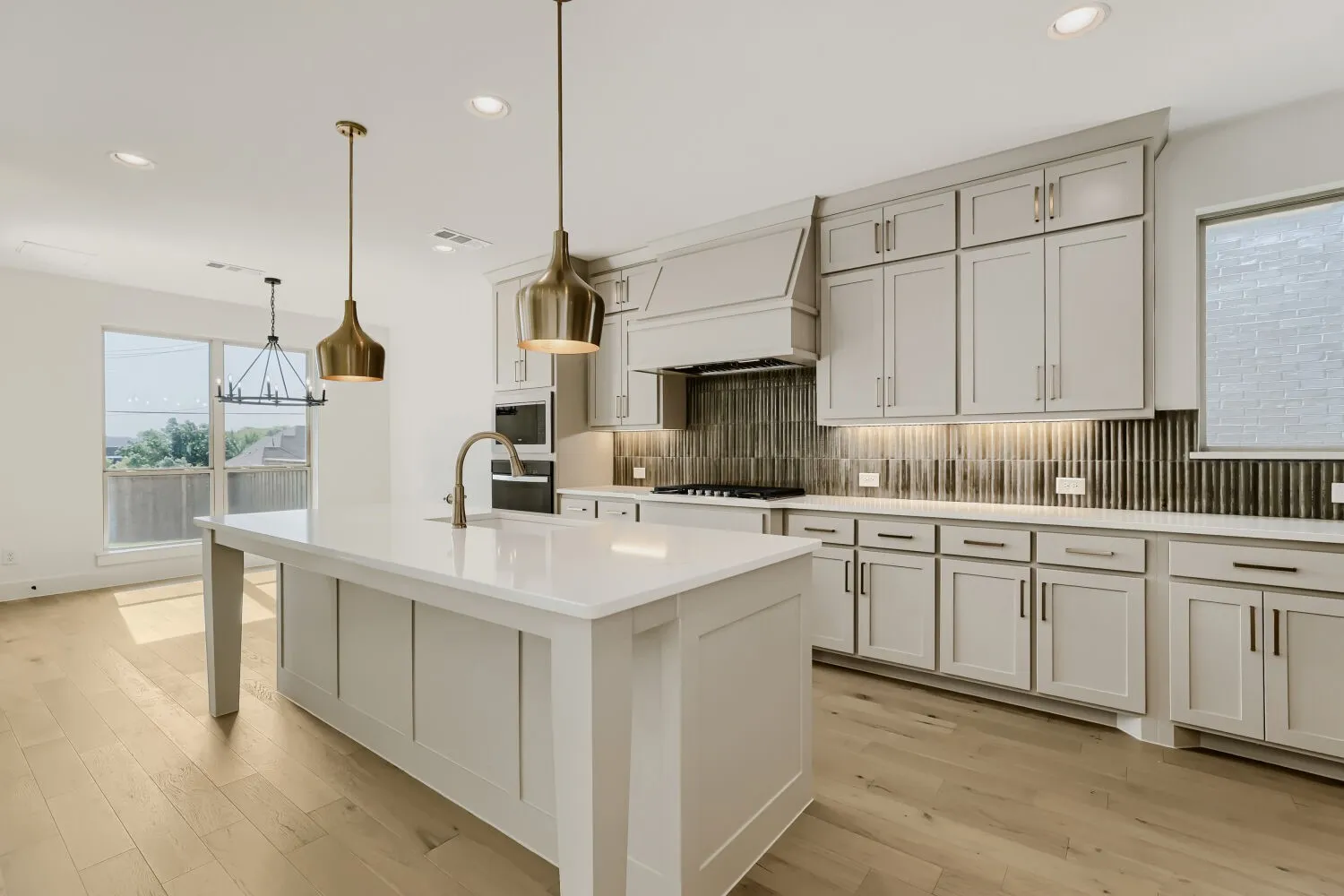 Sophisticated kitchen featuring white shaker-style cabinetry, quartz countertops, and a generously proportioned island with seating