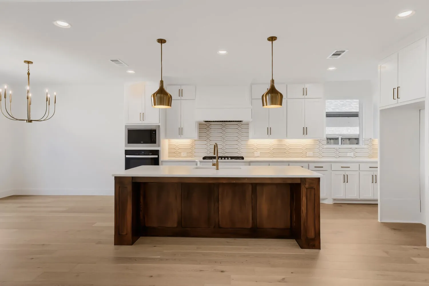 Gourmet kitchen featuring a wood-panel island, white cabinetry, integrated stainless steel appliances, and wood-finish flooring