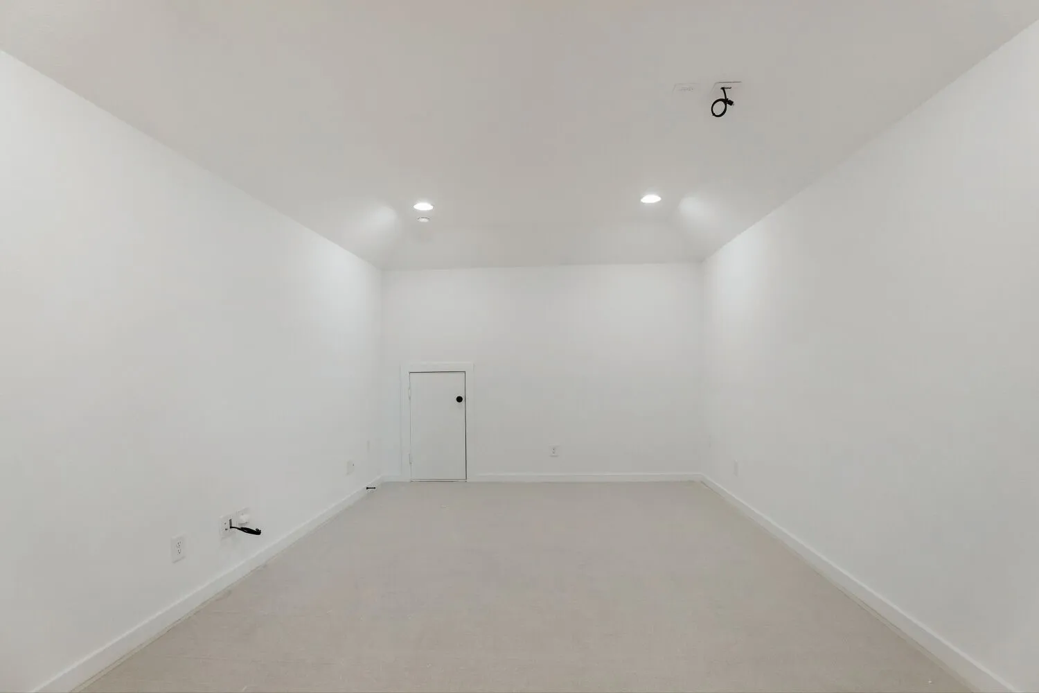 Recessed lighting, sloped ceiling, light-toned carpeting, white interior door, and white painted walls