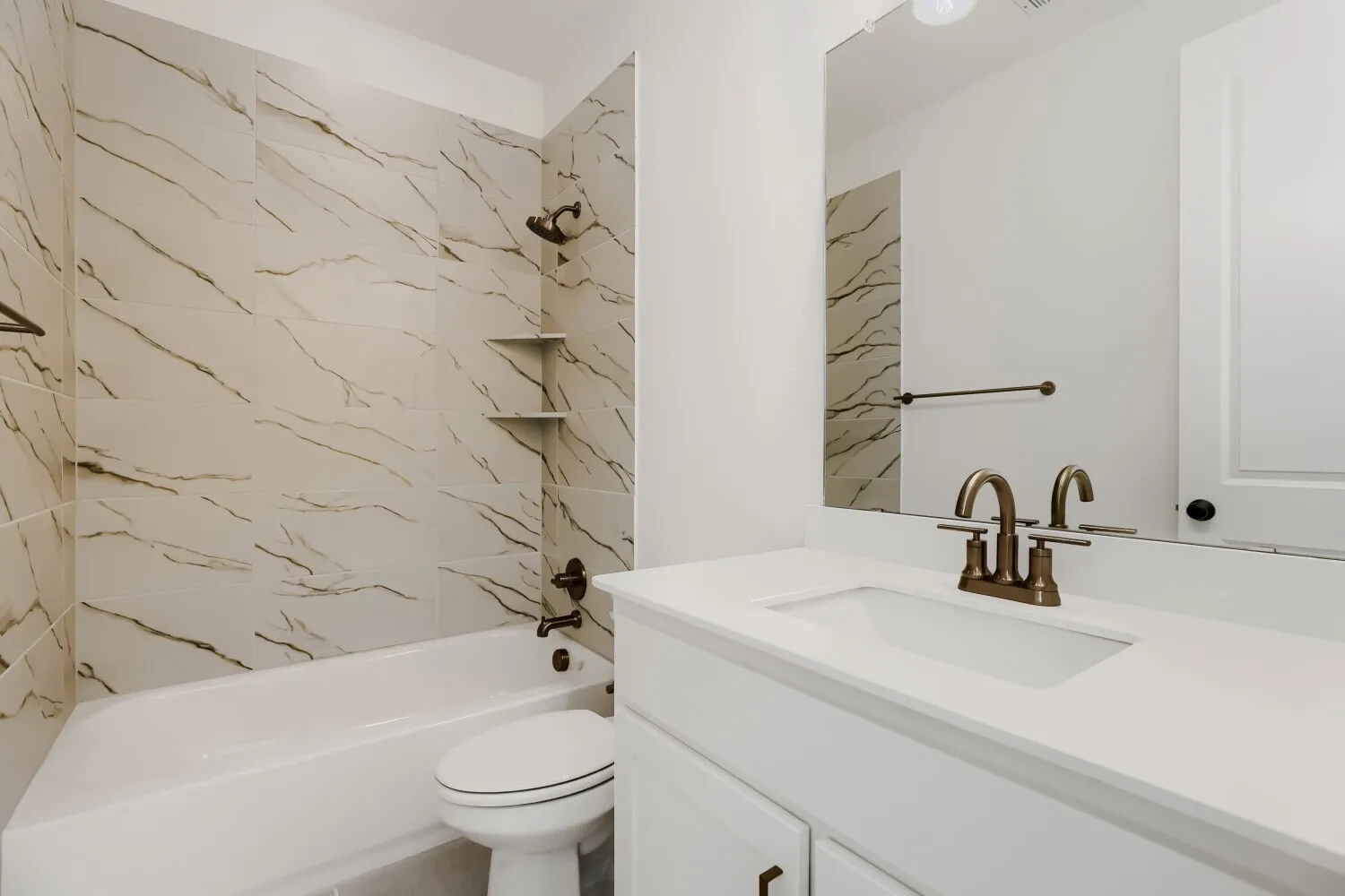 White vanity with integrated sink and bronze-finish faucet