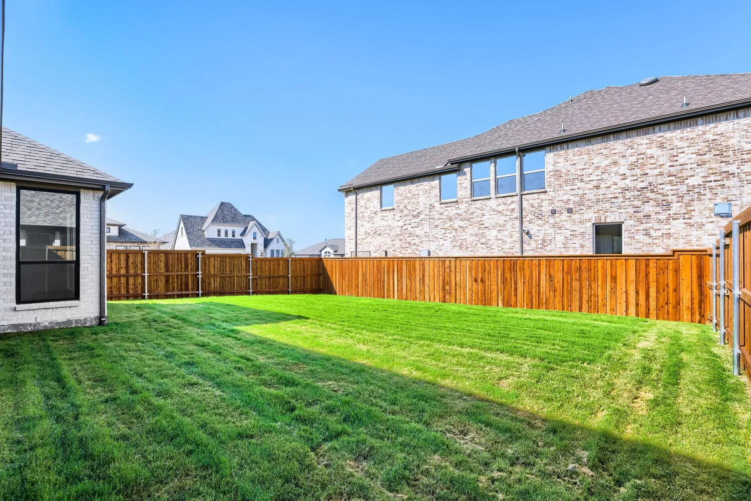 Expansive grassy yard with a privacy fence