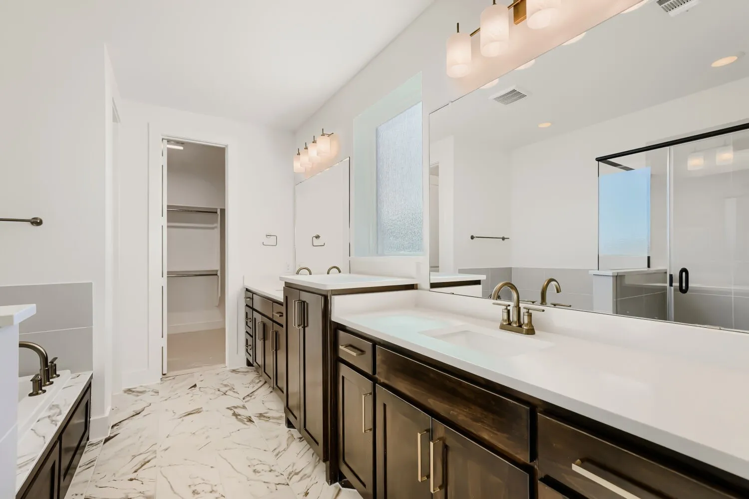 Dual vanity with dark wood-finish cabinetry, white countertops, and integrated sinks