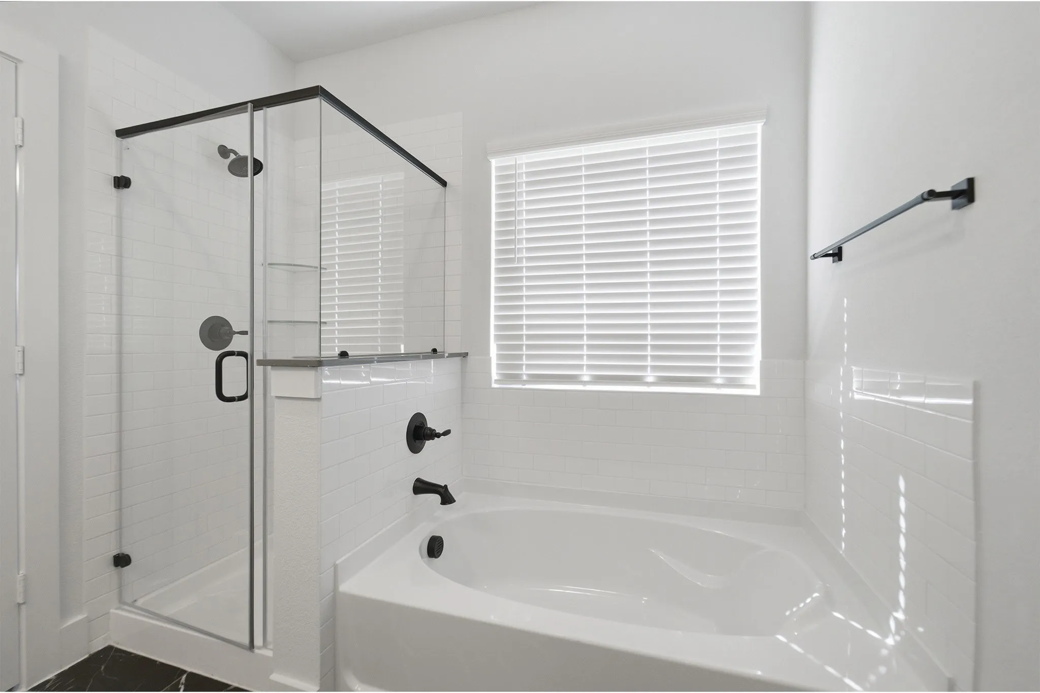 Contemporary bathroom featuring a corner soaking tub and glass-enclosed shower with black hardware