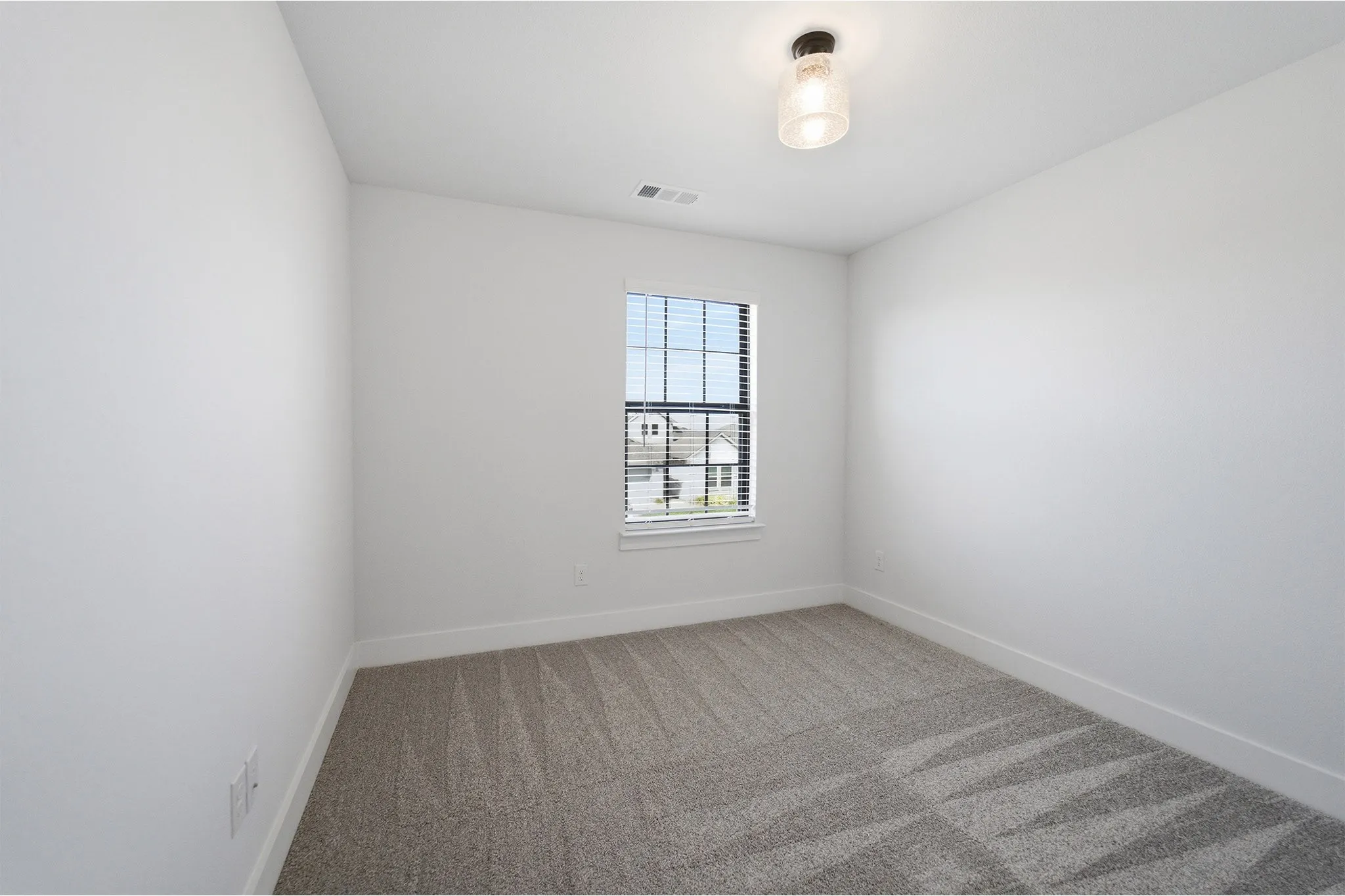 Neutral tone interior with carpet flooring, a single window featuring horizontal blinds, and a flush mount ceiling light fixture