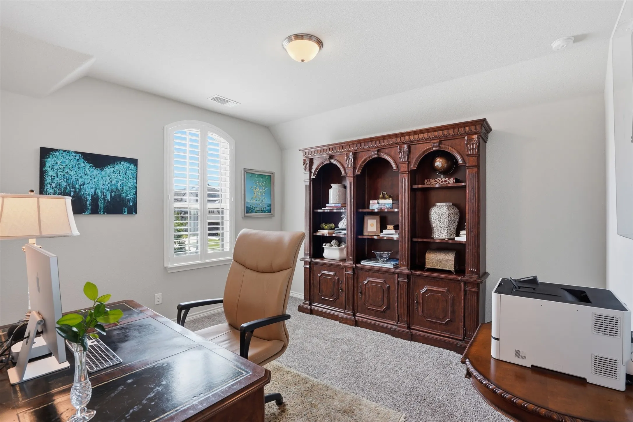 Spacious room featuring a decorative built-in wooden bookcase with open shelving and lower cabinetry