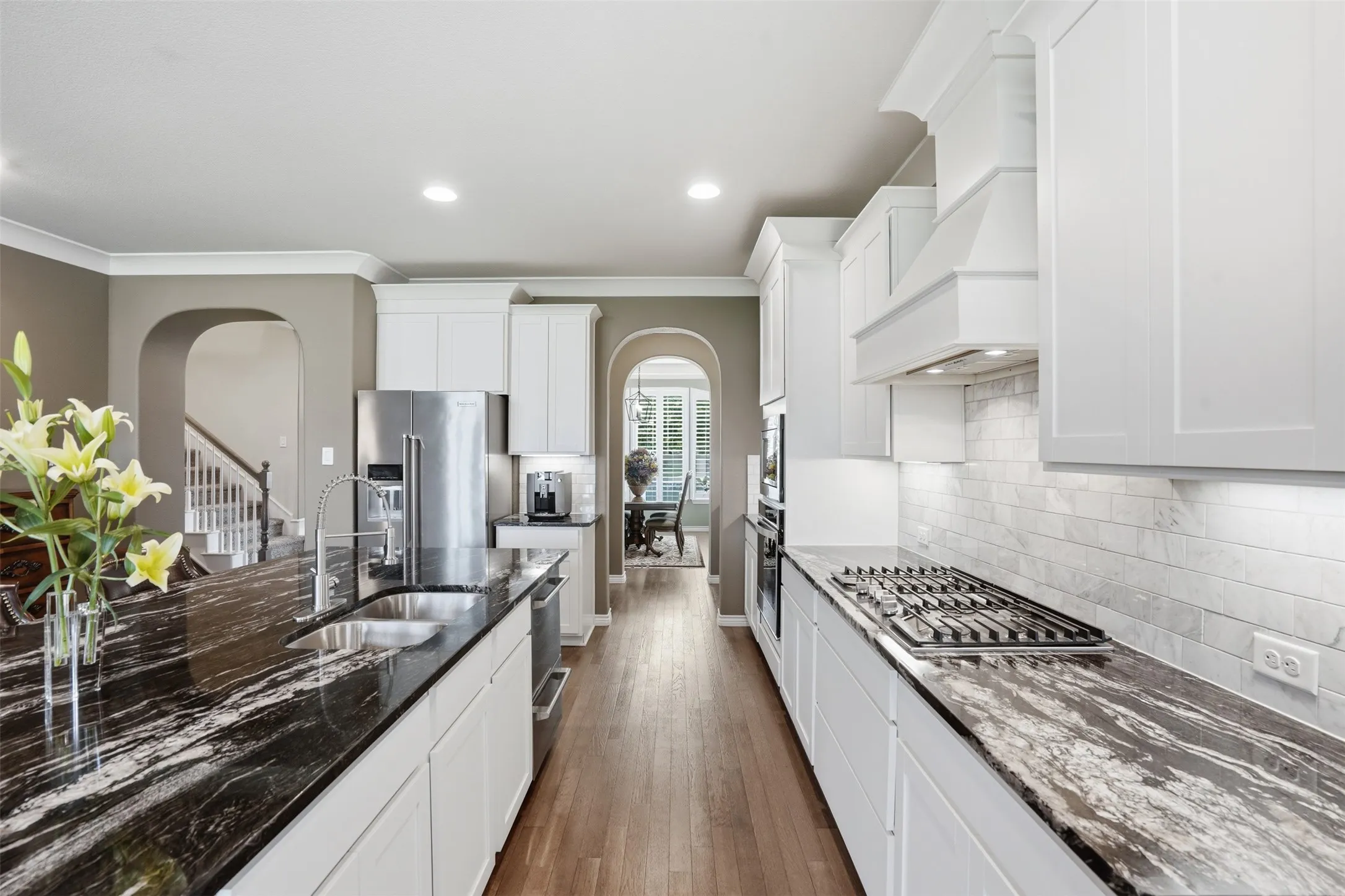 Kitchen featuring a gas range, white shaker cabinetry, stainless steel appliances, and dark patterned countertops