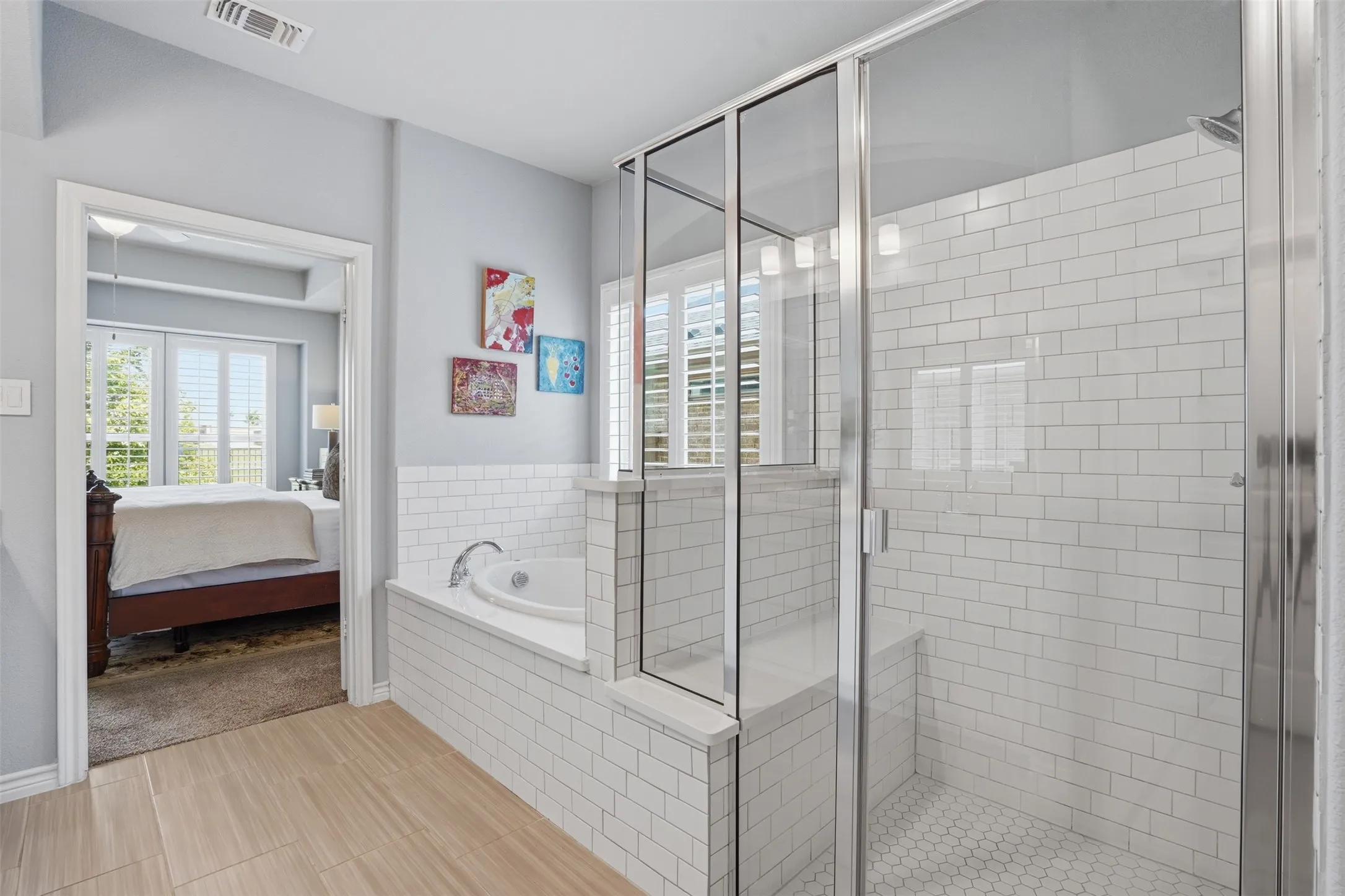 Bathroom featuring a walk-in shower with white subway tile, a built-in bench, and a hexagonal tile floor