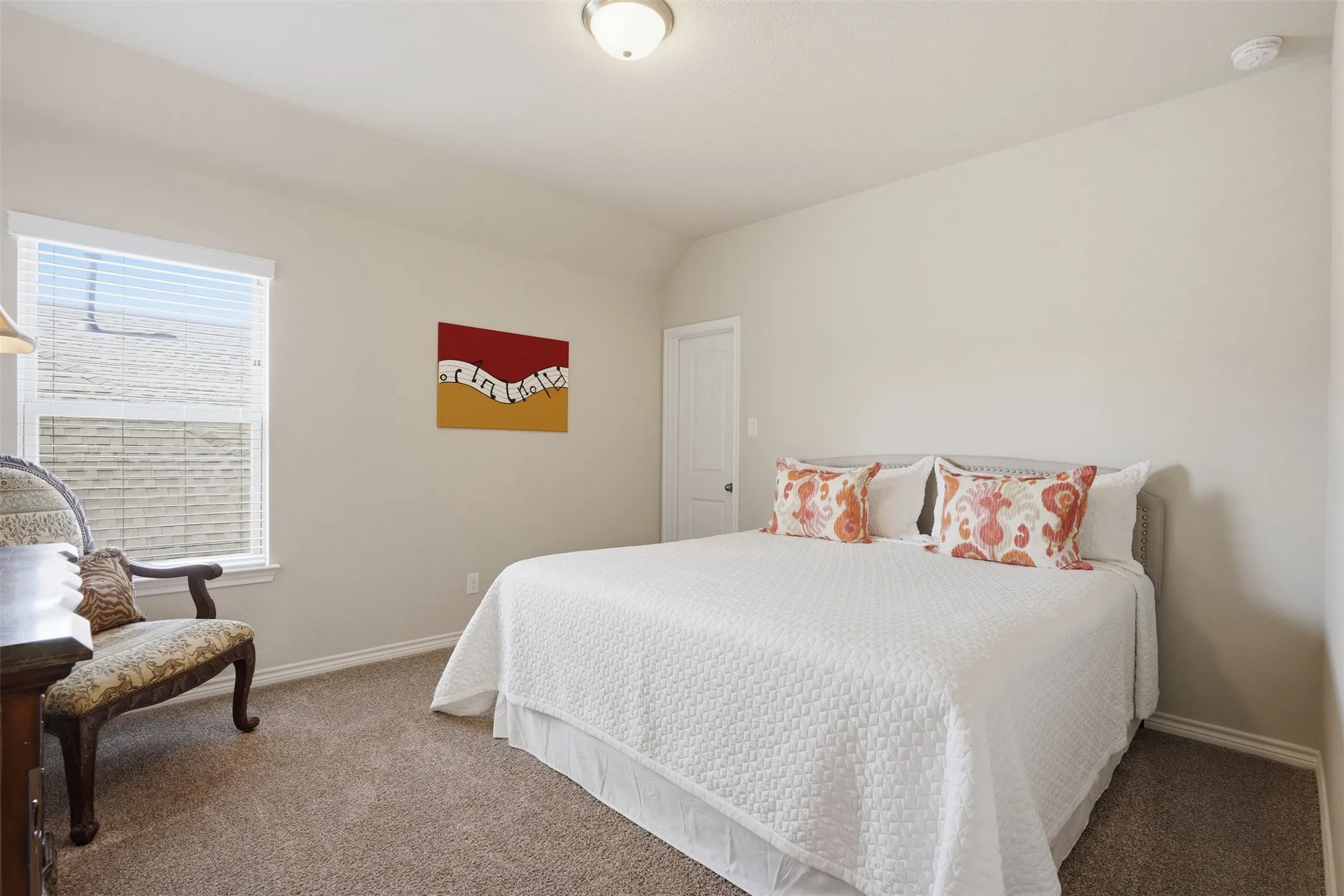 Carpeted room featuring a single window with blinds, a built-in light fixture, and neutral wall tones