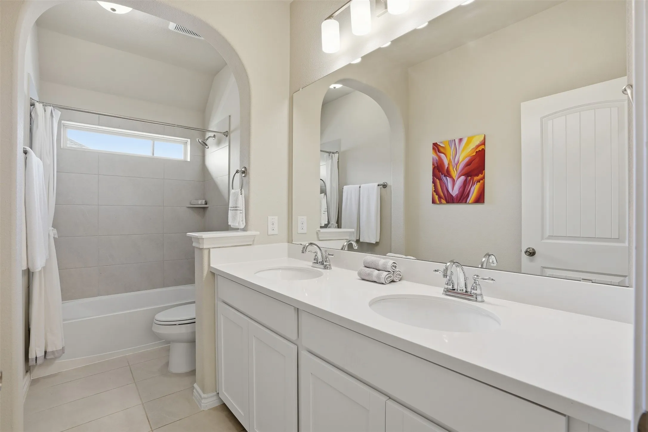 Double vanity with white cabinetry, dual sinks, and chrome faucets