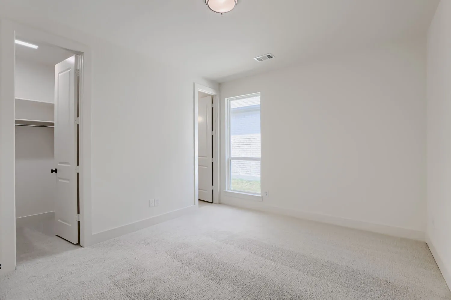 Carpeted room featuring a single window and recessed lighting