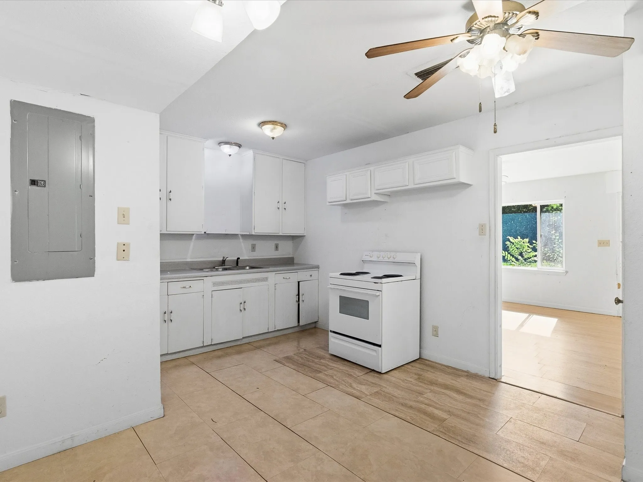Kitchen featuring white cabinetry with brushed nickel hardware, a white electric range, a stainless steel sink, wood-finish flooring, and a ceiling fan with integrated lighting