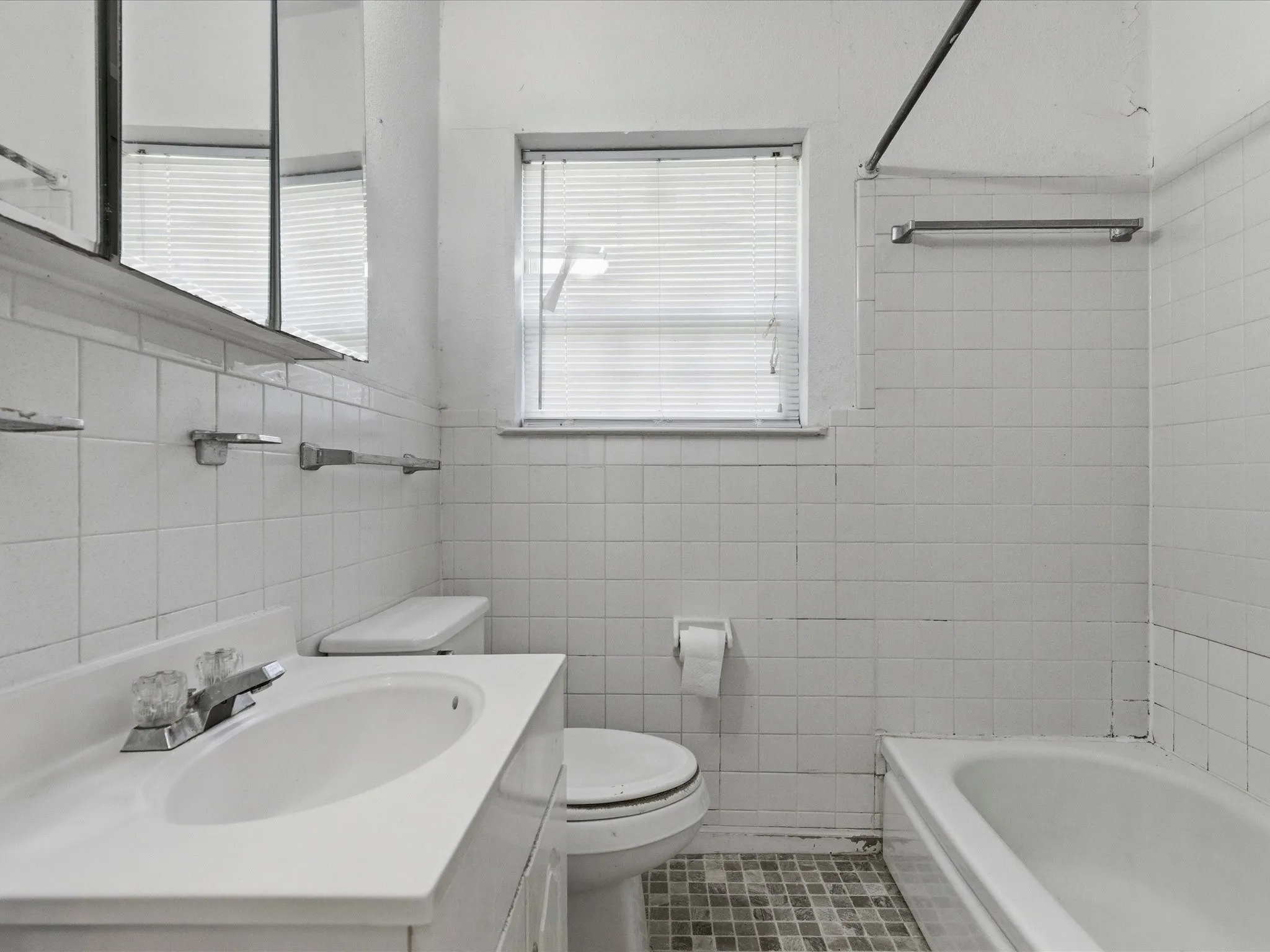 Bathroom featuring a single vanity with an integrated sink, polished chrome faucet, and a wall-mounted medicine cabinet