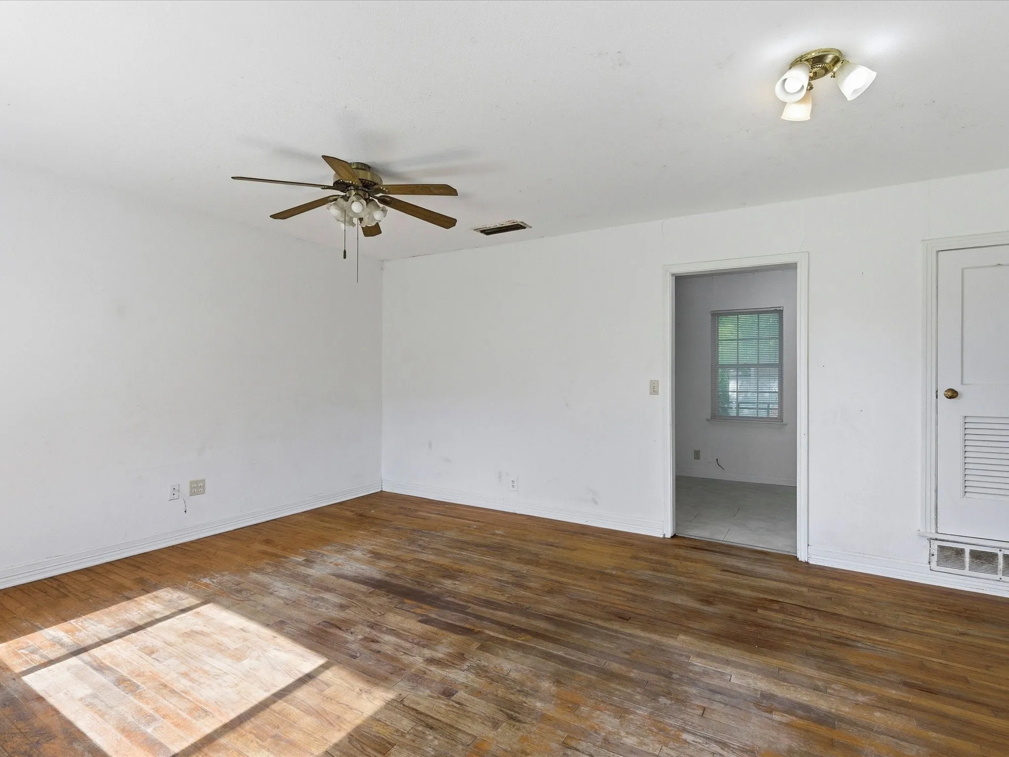 Spacious room with wood-finish flooring, ceiling fan, and recessed lighting