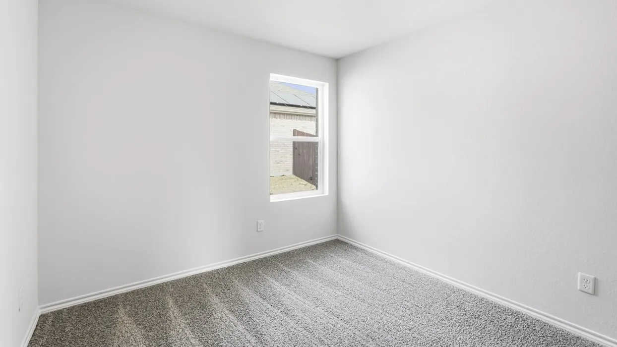 Neutral tone walls, grey textured carpeting, white baseboards, and a single pane window