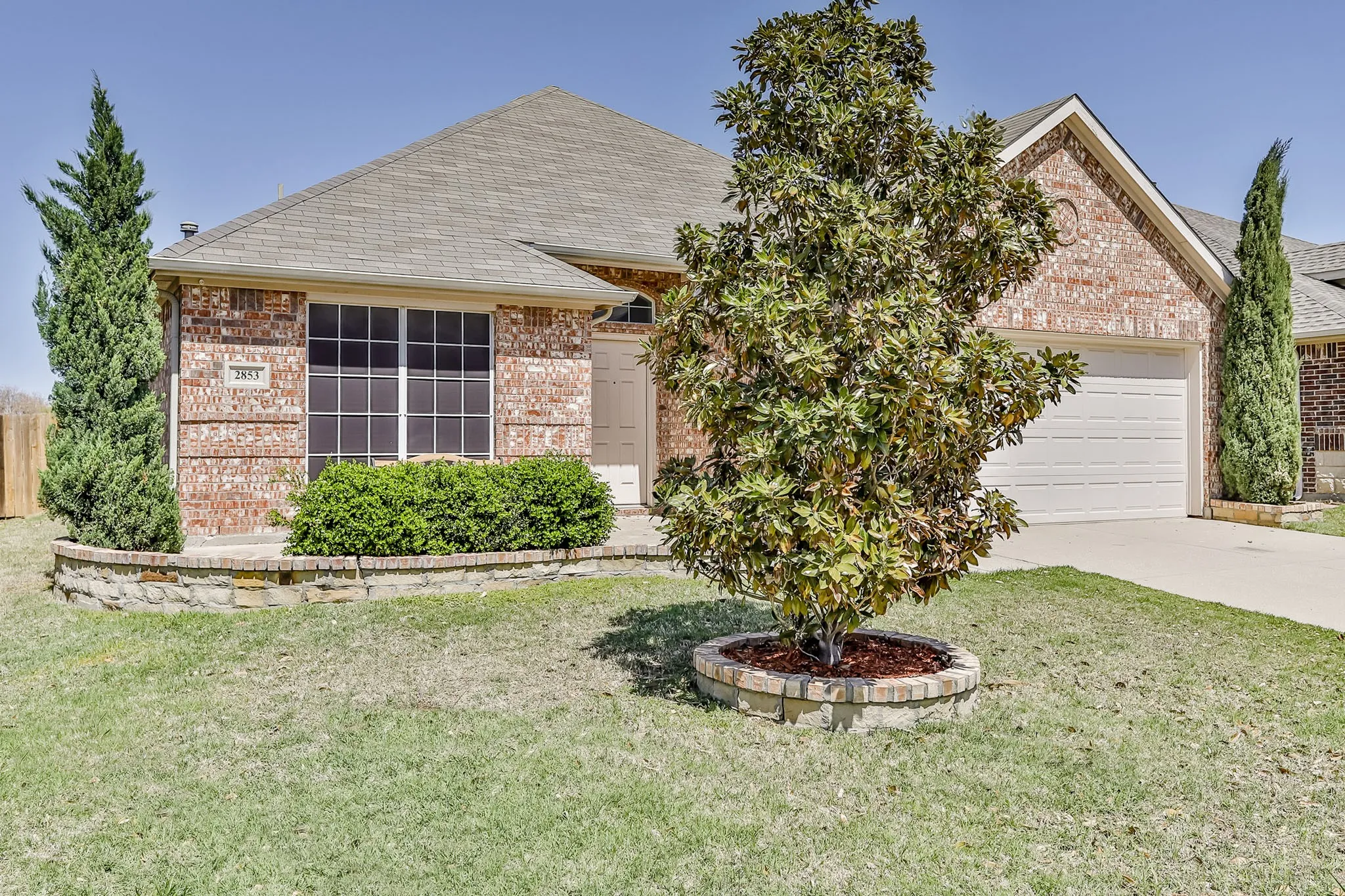 Brick exterior with a gabled roof and attached garage