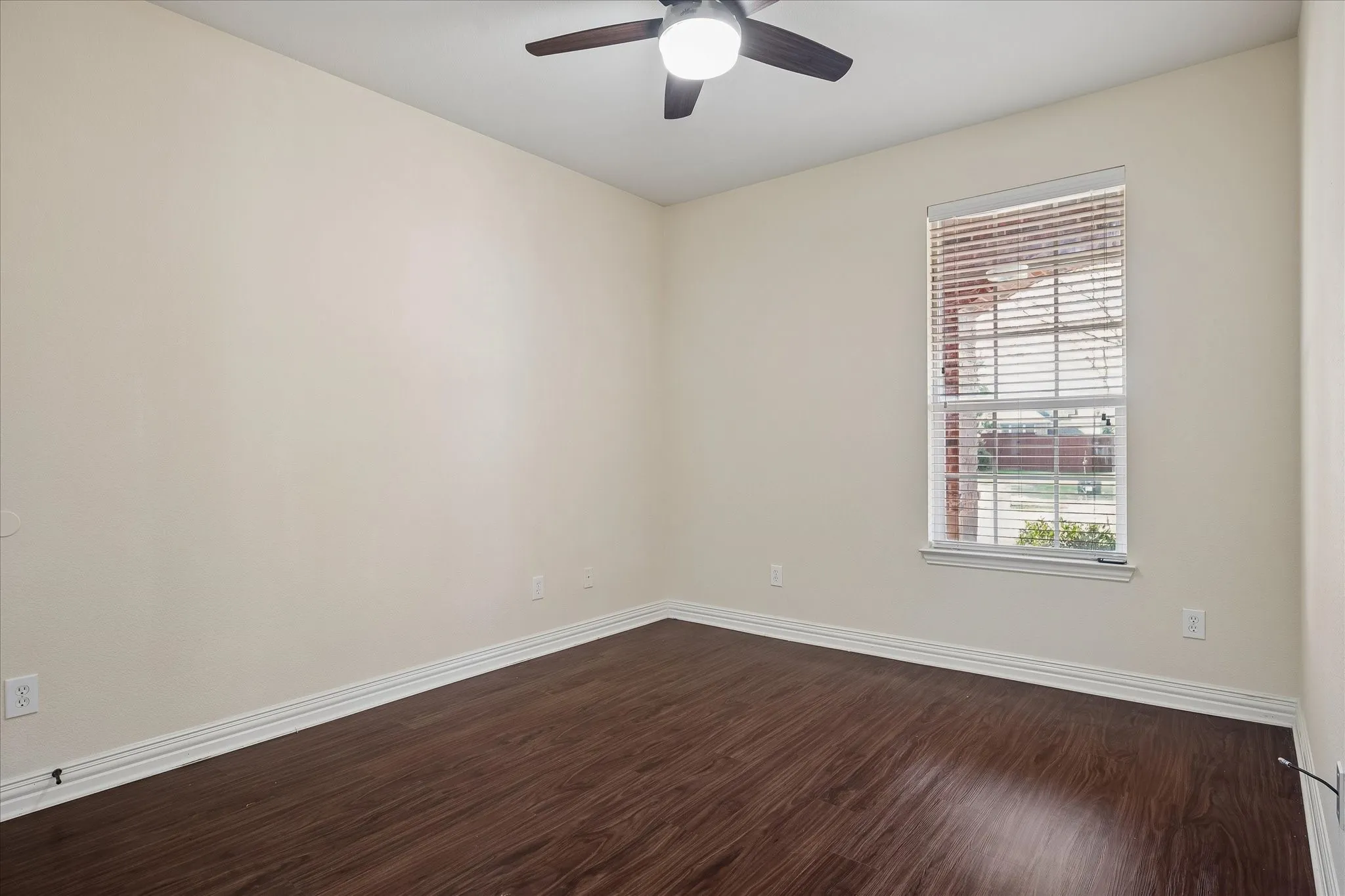 Wood-finish flooring, ceiling fan with integrated lighting, single window with blinds, and neutral wall tones