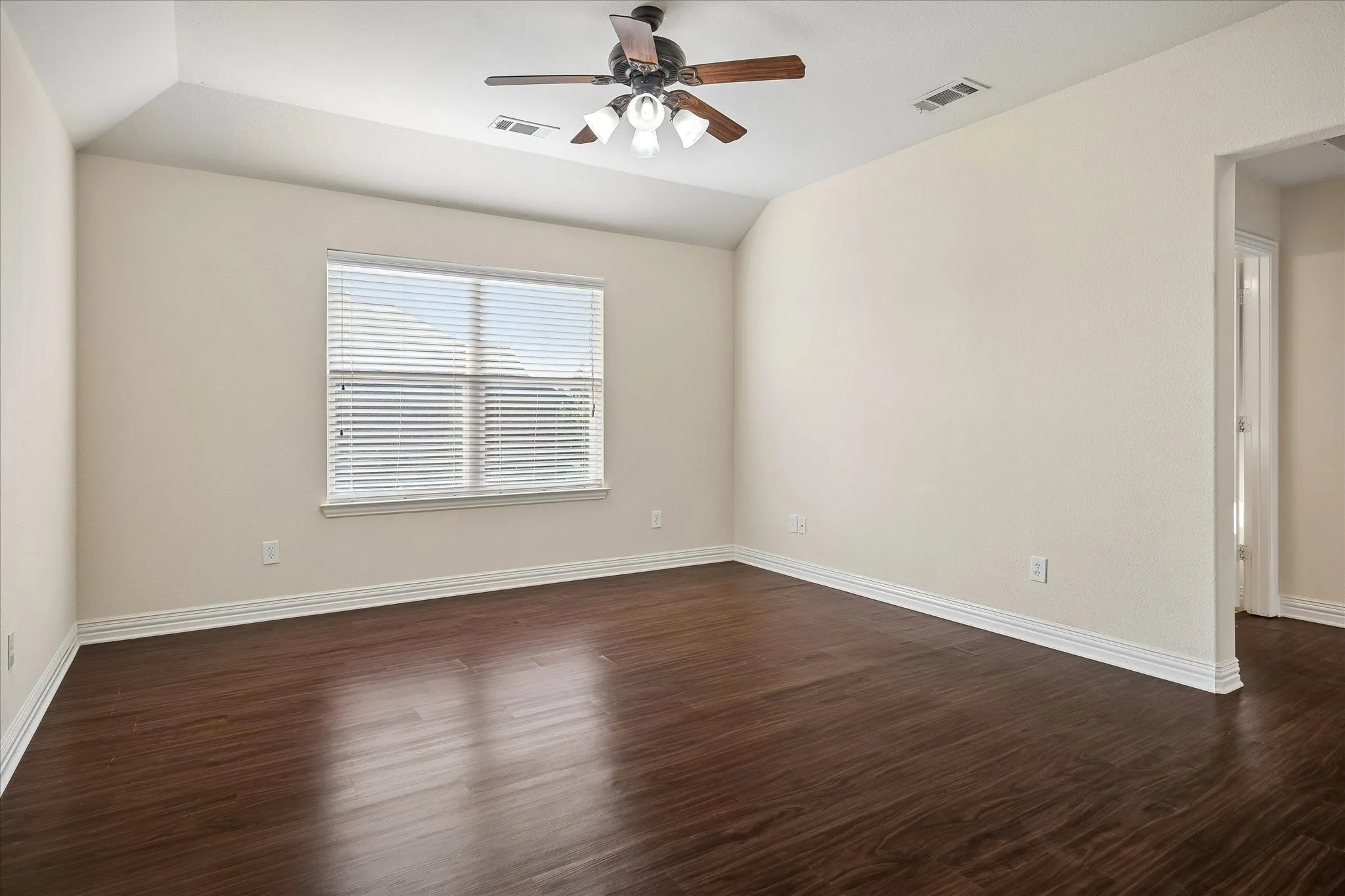 Wood-finish flooring, single window with blinds, ceiling fan with light fixture, and neutral wall tones