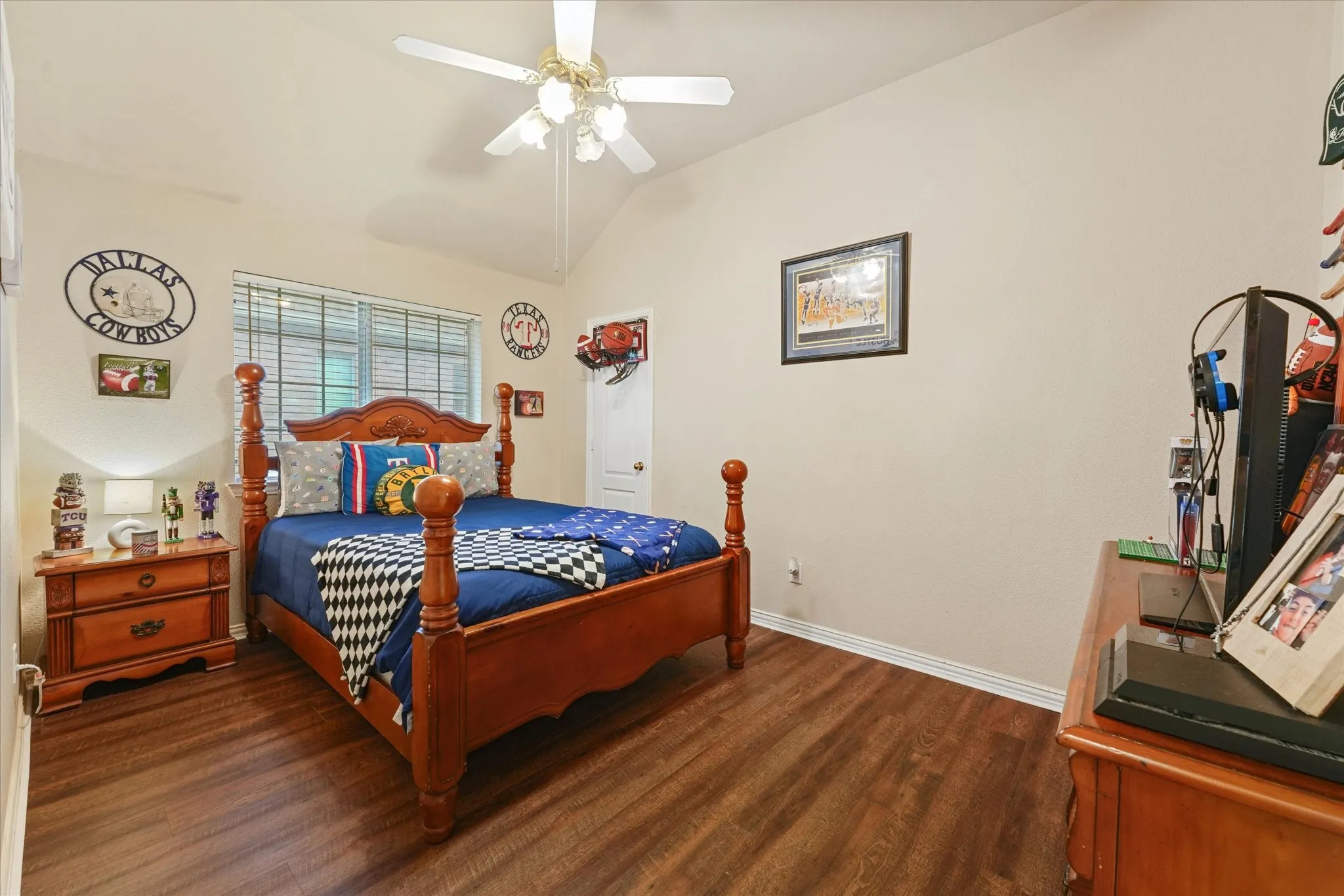 Spacious secondary bedroom with vaulted ceilings, luxury vinyl plank flooring, and a large window overlooking the backyard. The room offers flexibility for family, guests, or a home office.