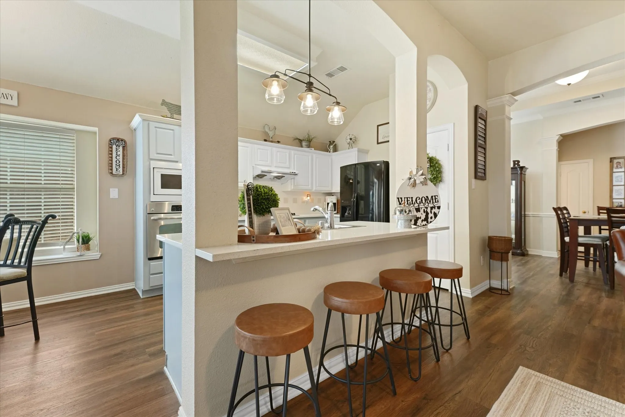 Oversized breakfast bar with seating for four creates additional dining and gathering space. The kitchen opens directly to the living room and breakfast nook, making it easy to stay connected while cooking, dining, or hosting guests.