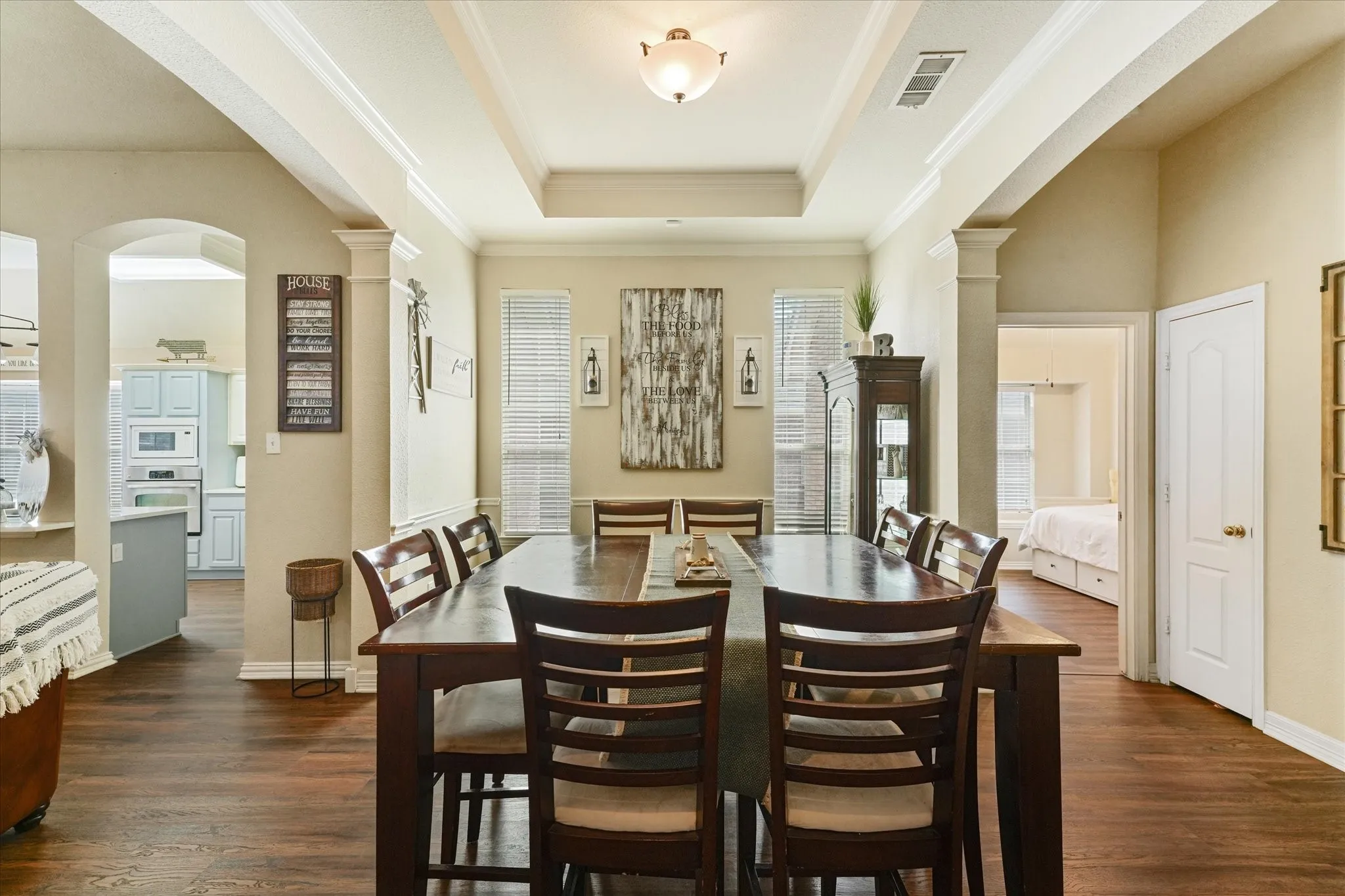 Dedicated dining room with crown molding, decorative columns, and recessed ceiling details. This central space is ideal for holiday gatherings, dinner parties, or everyday meals with family and friends.