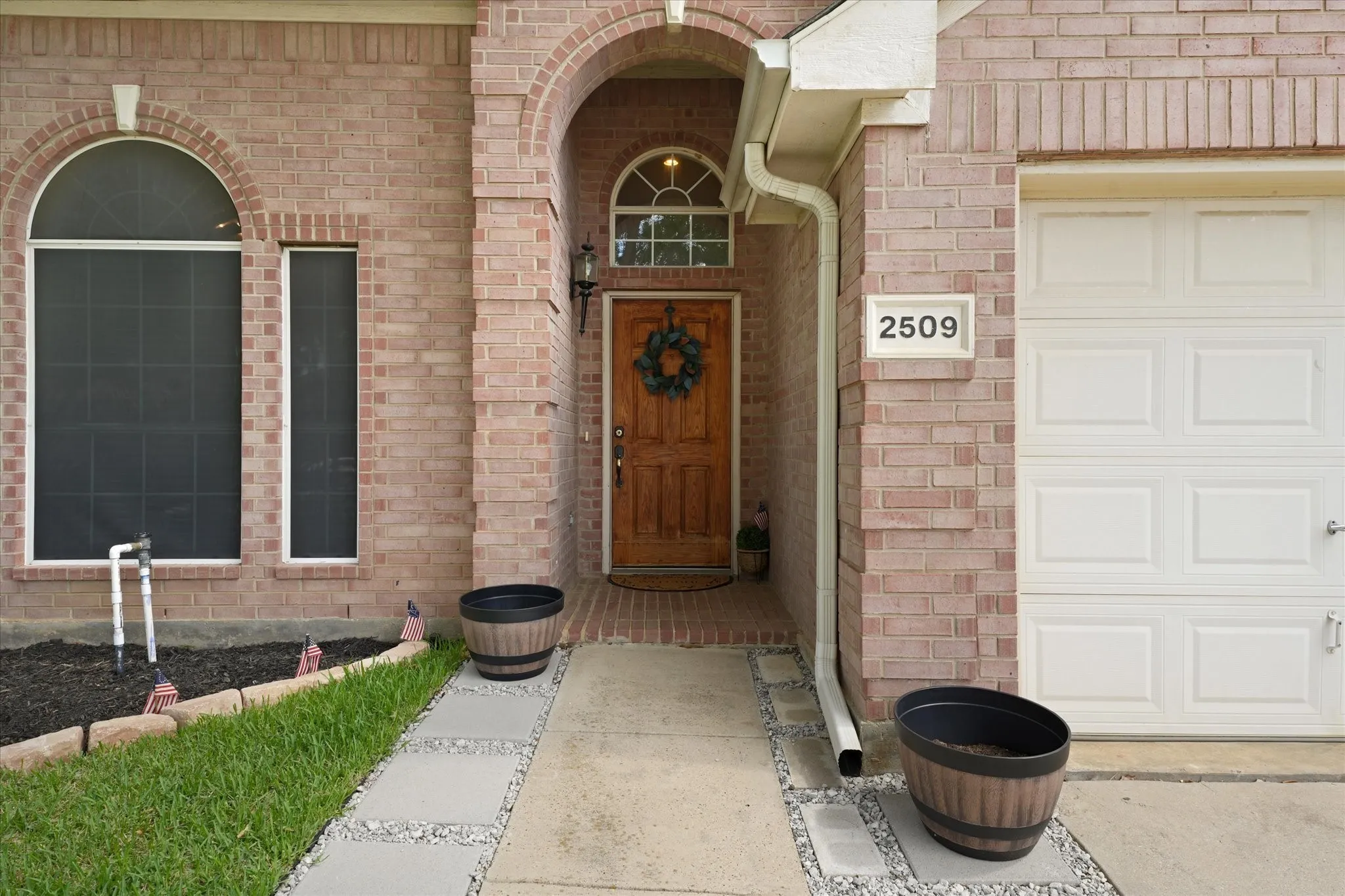 Inviting covered entry with a solid wood front door, arched architectural details, and a welcoming approach. The mature landscaping and well-maintained exterior create a strong first impression from the moment you arrive.
