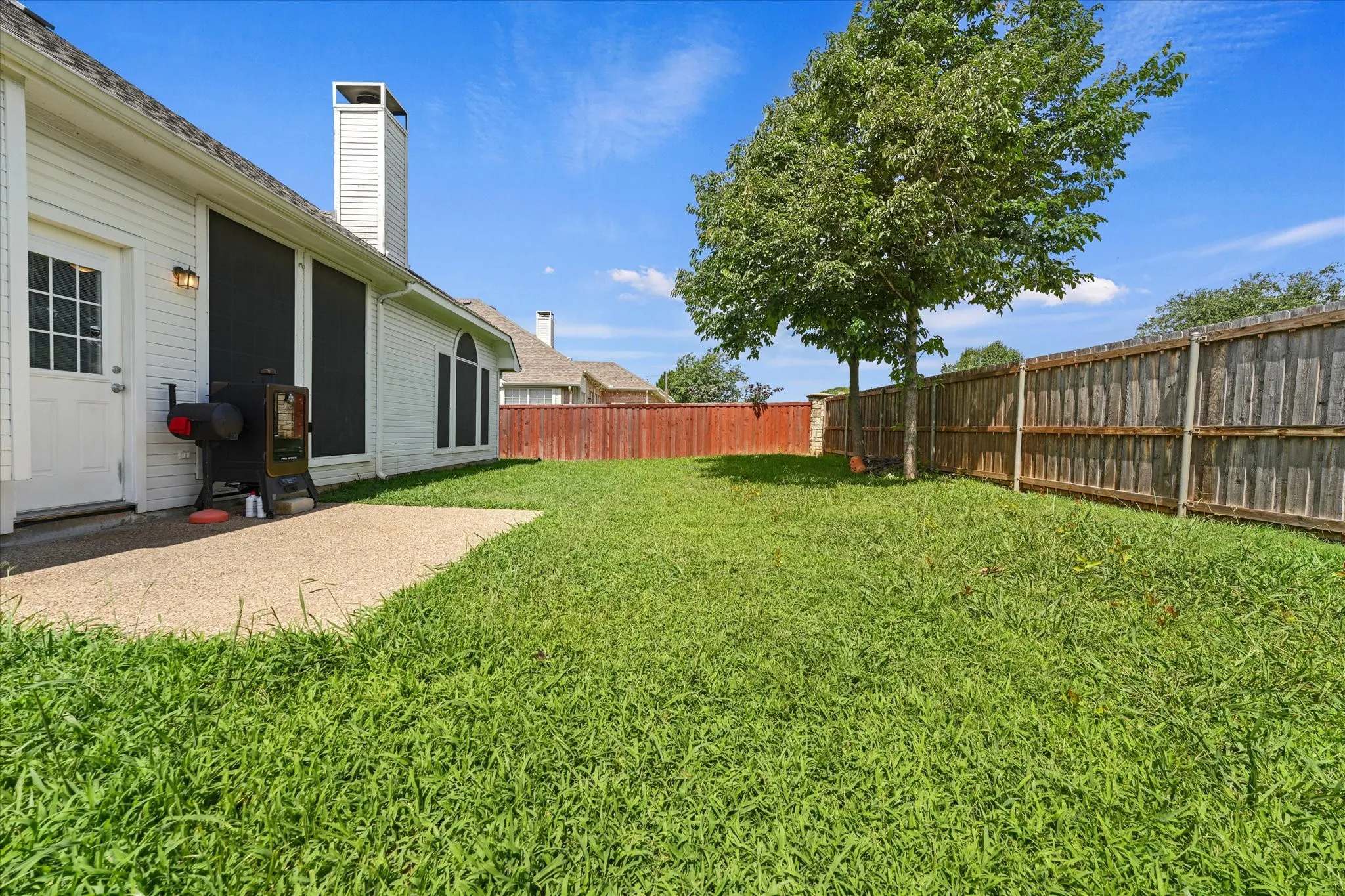 Generous backyard with mature shade tree, open green space, and privacy fencing. Plenty of room for pets, play equipment, gardening, or future outdoor enhancements.