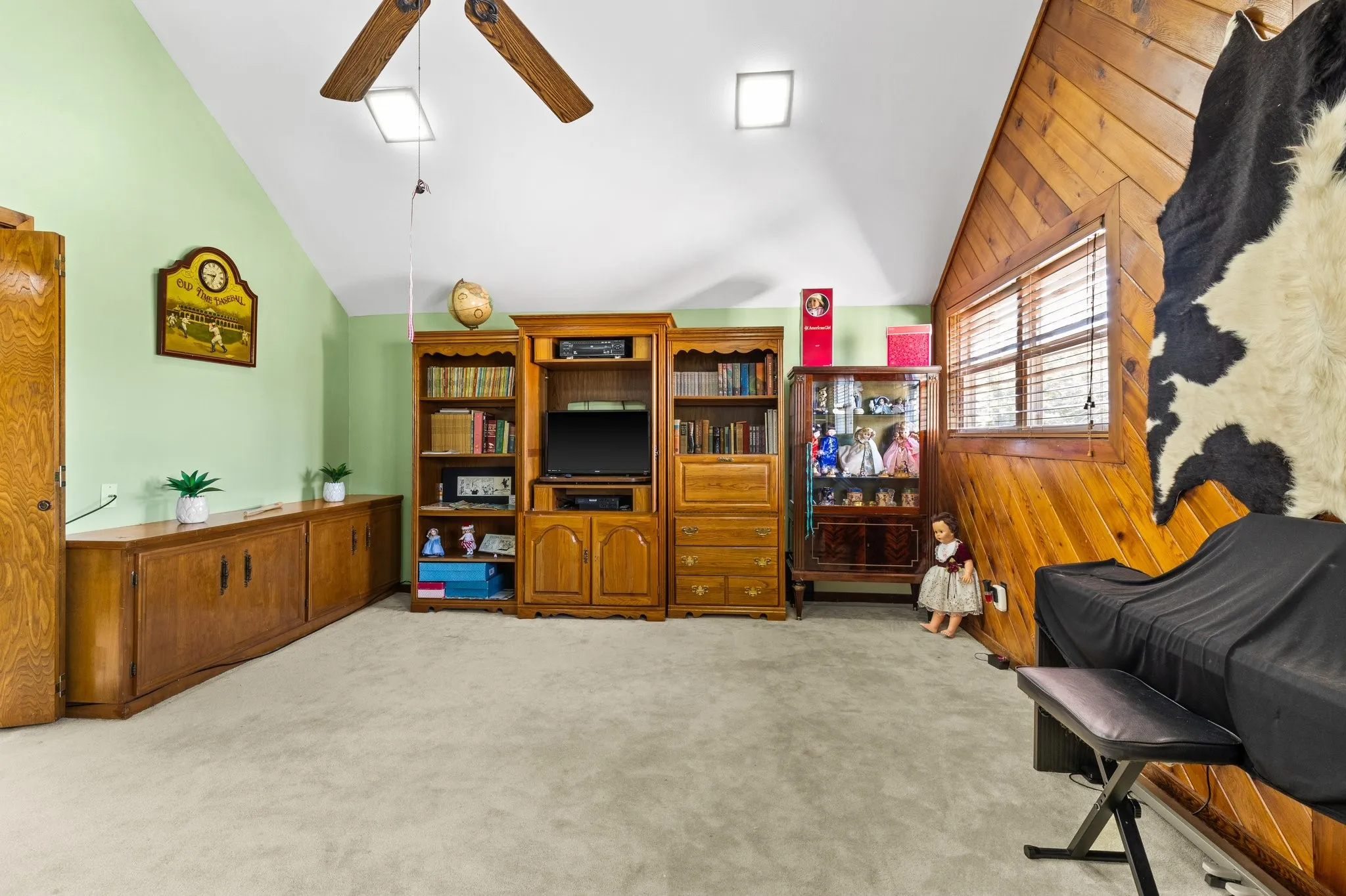 Game Rm with vaulted ceiling, cedar-paneled wall,ceiling fan and natural light.
