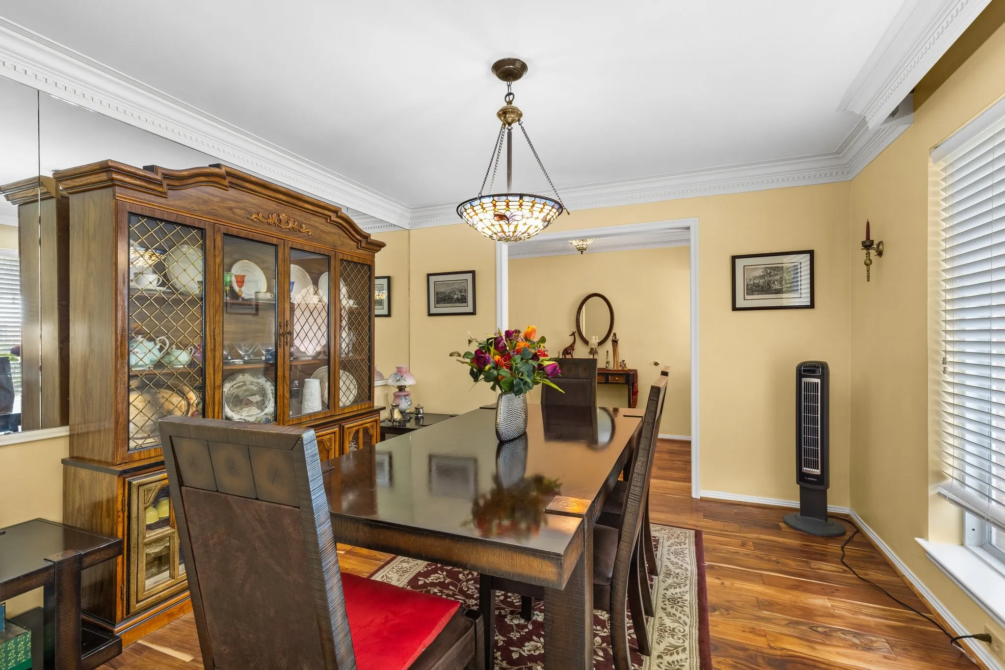 Dining with dentil-crown molding and Mahogony floors.