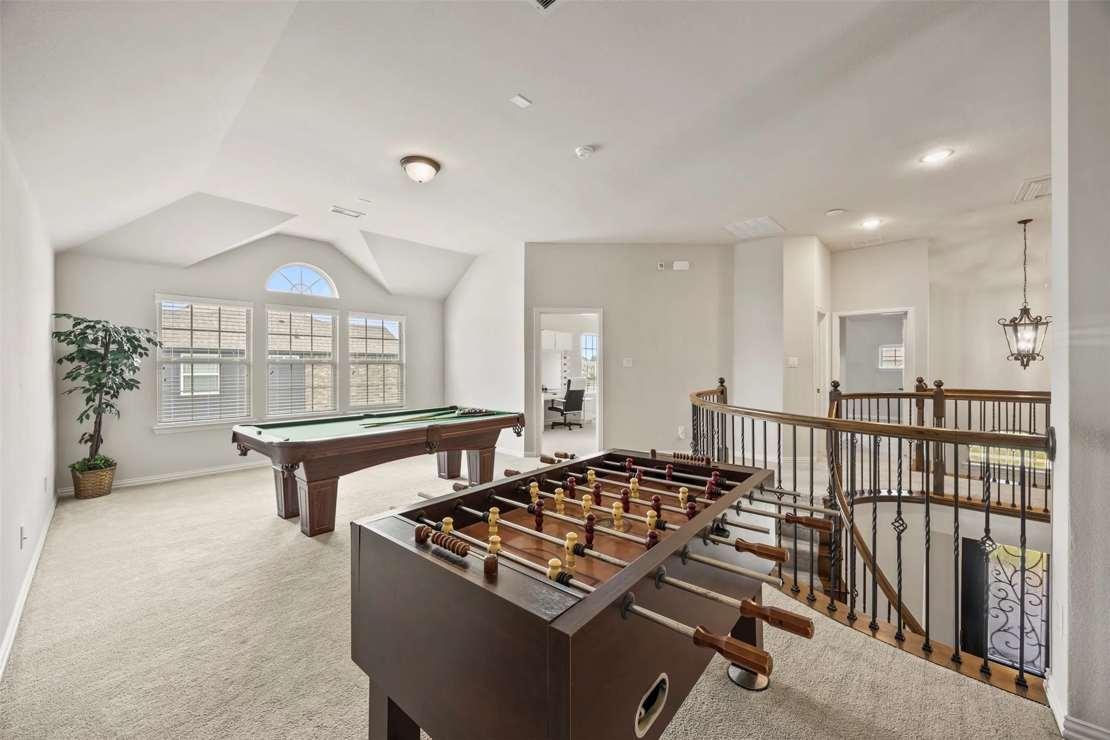 Spacious second-level bonus room with vaulted ceilings and ample natural light from multiple windows