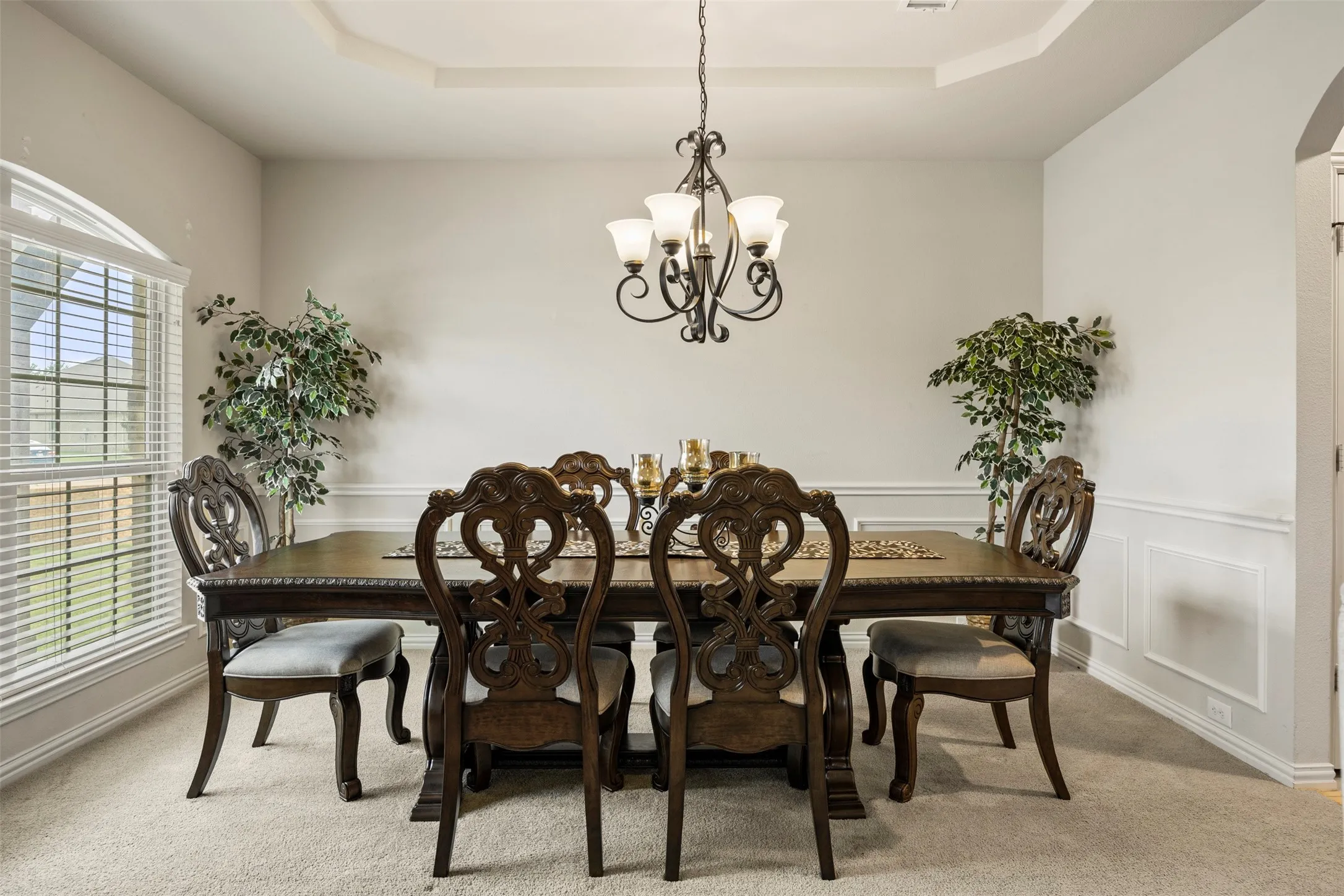 Formal dining area with tray ceiling, chandelier lighting, and wainscoting... perfect for all your casual dining or entertaining needs