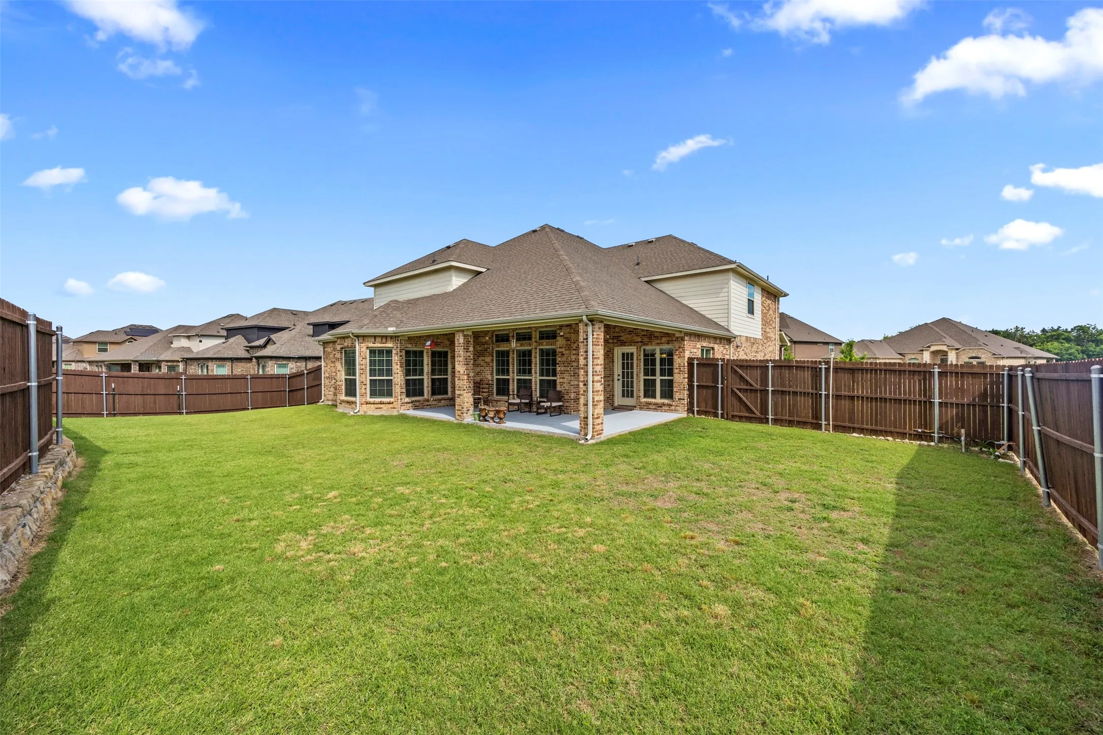 Huge backyard with a covered patio and full privacy fencing. Perfect for grilling, gatherings, and games
