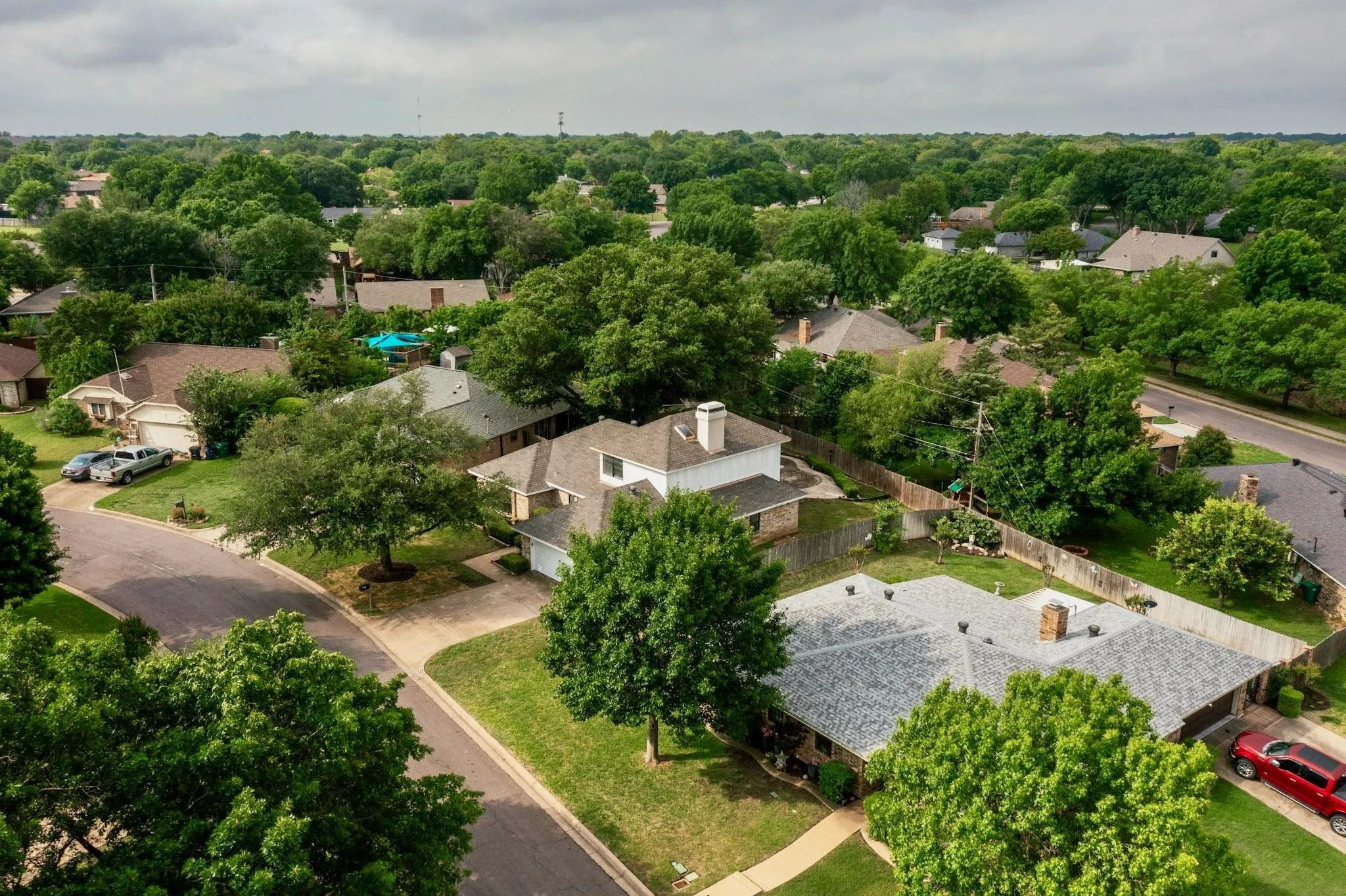 Aerial perspective showcasing a residential neighborhood with extensive mature tree cover