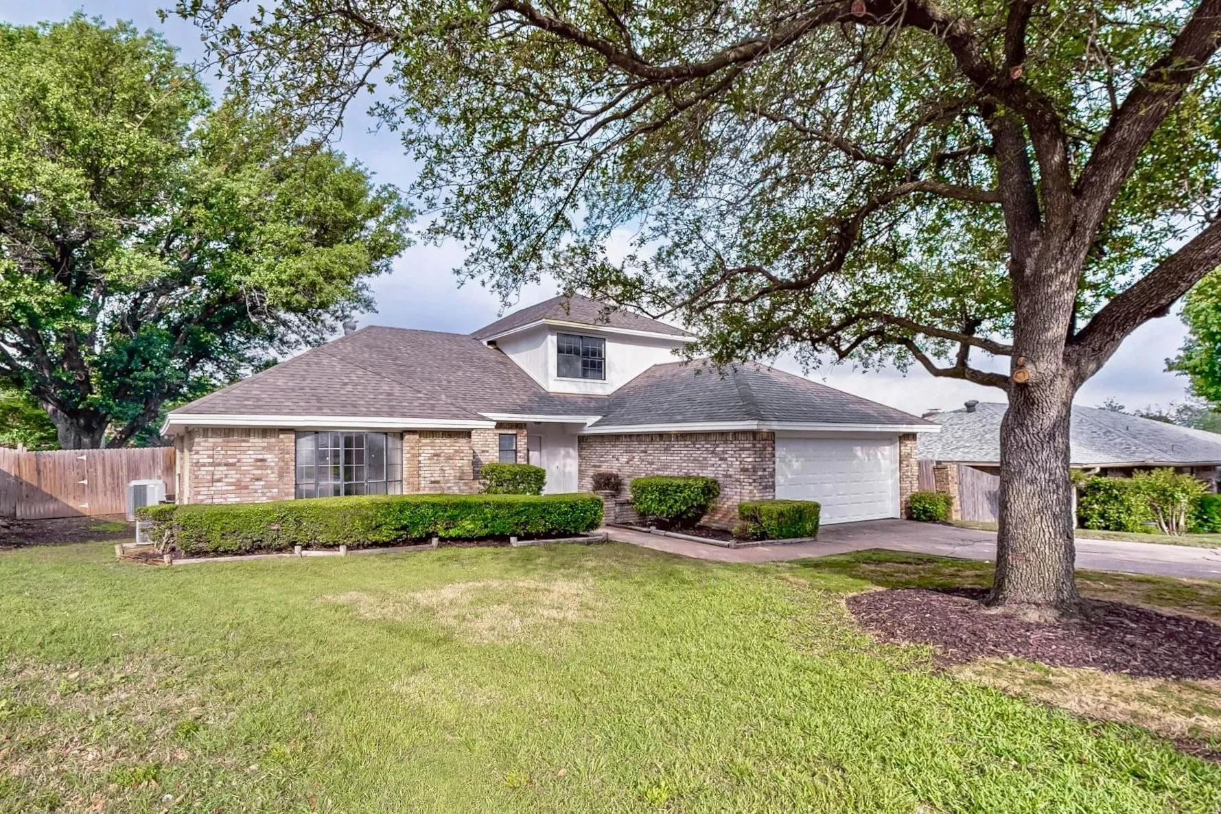 Traditional brick exterior with white trim, featuring a two-car garage