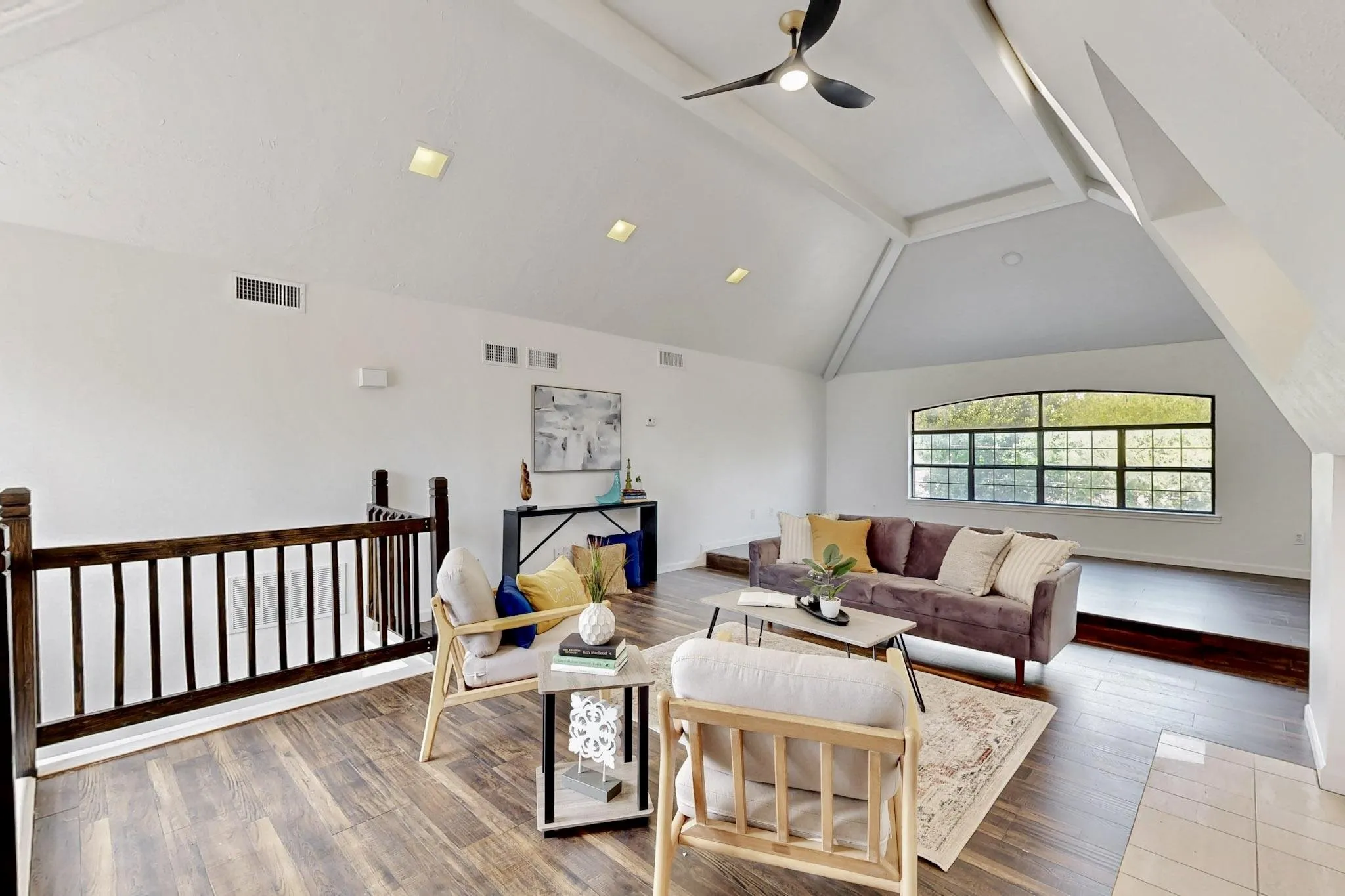 Spacious living area featuring high vaulted ceilings, recessed lighting, and wood-finish flooring
