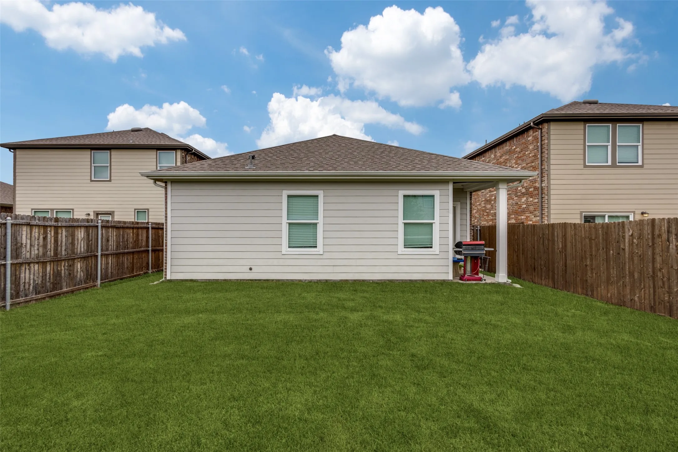 Expansive green lawn with a privacy fence
