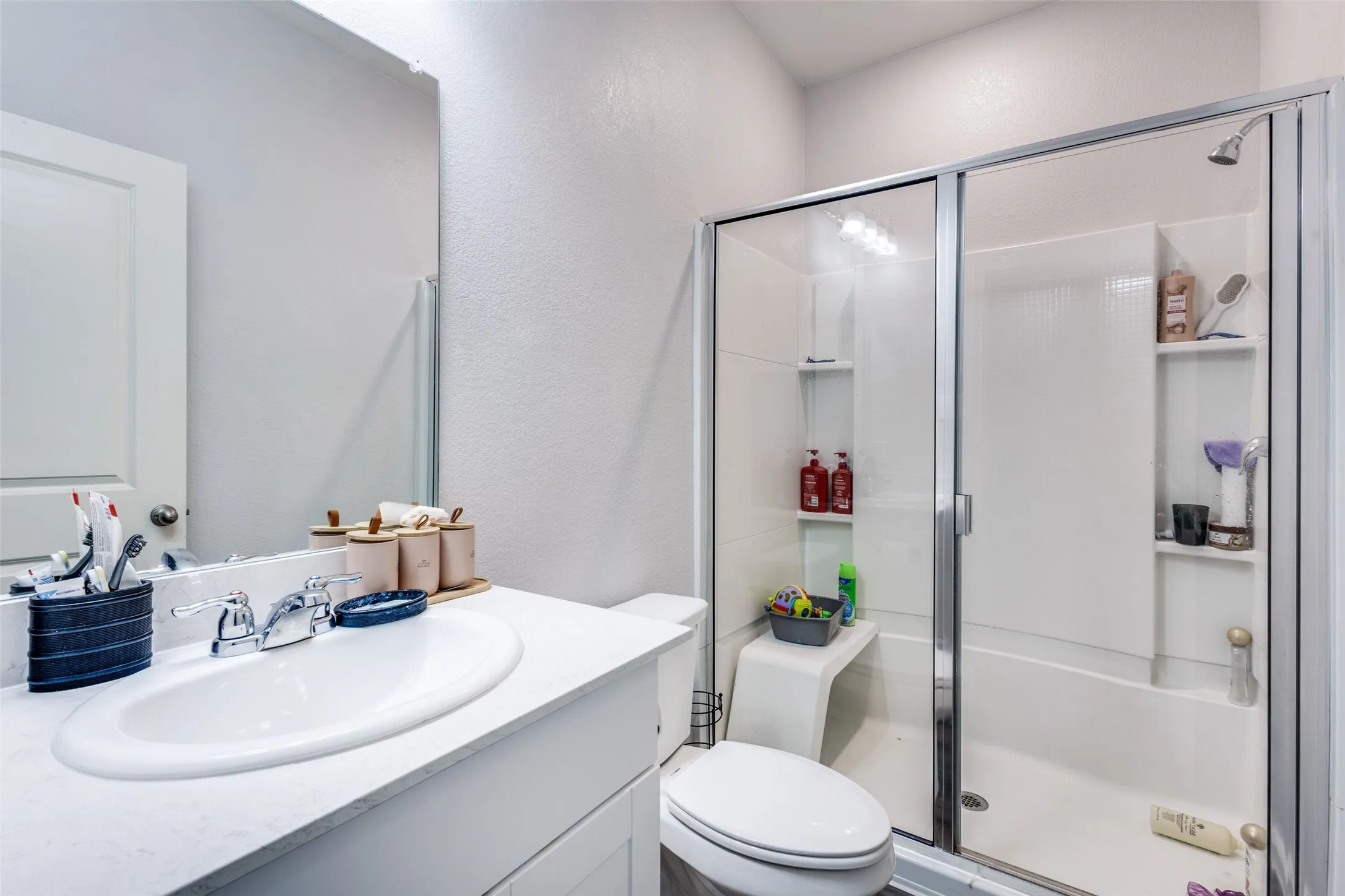 Bathroom featuring a white vanity with an undermount sink, chrome faucet, and a framed mirror