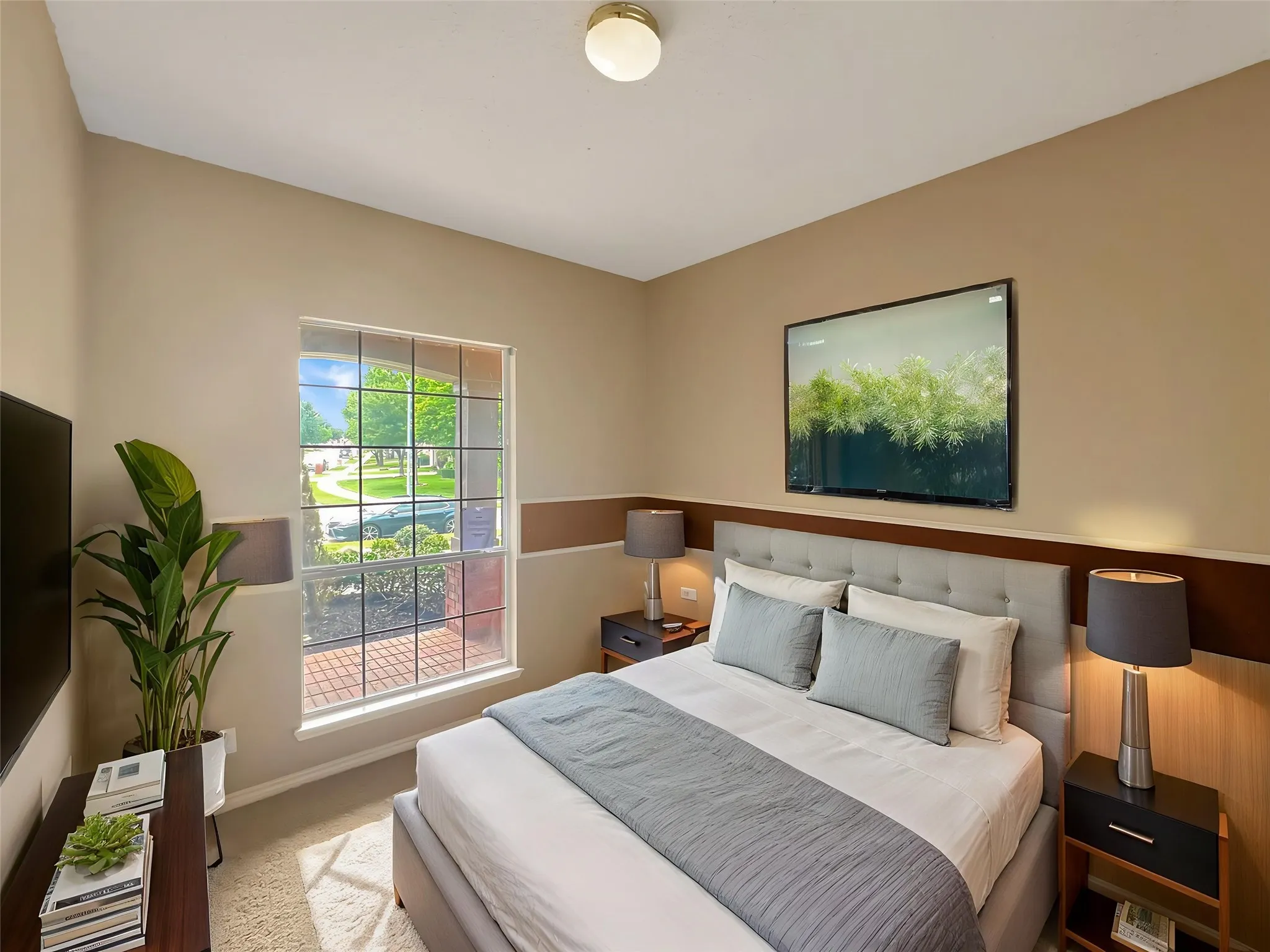 Spacious backyard featuring a manicured lawn, an extended patio with gravel, and mature landscaping with flowering shrubs