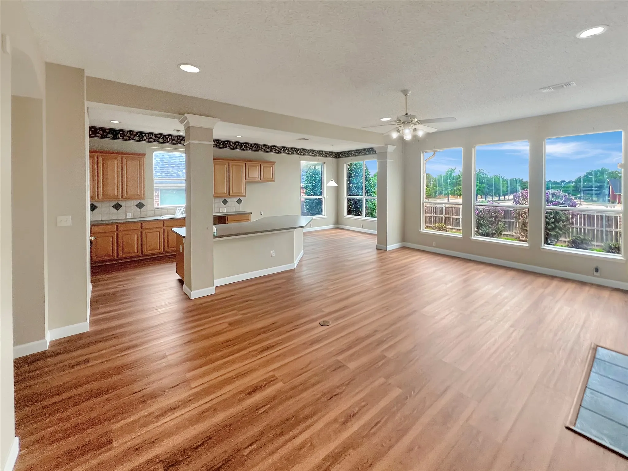 Spacious open-concept interior featuring wood-finish flooring, recessed lighting, and a ceiling fan