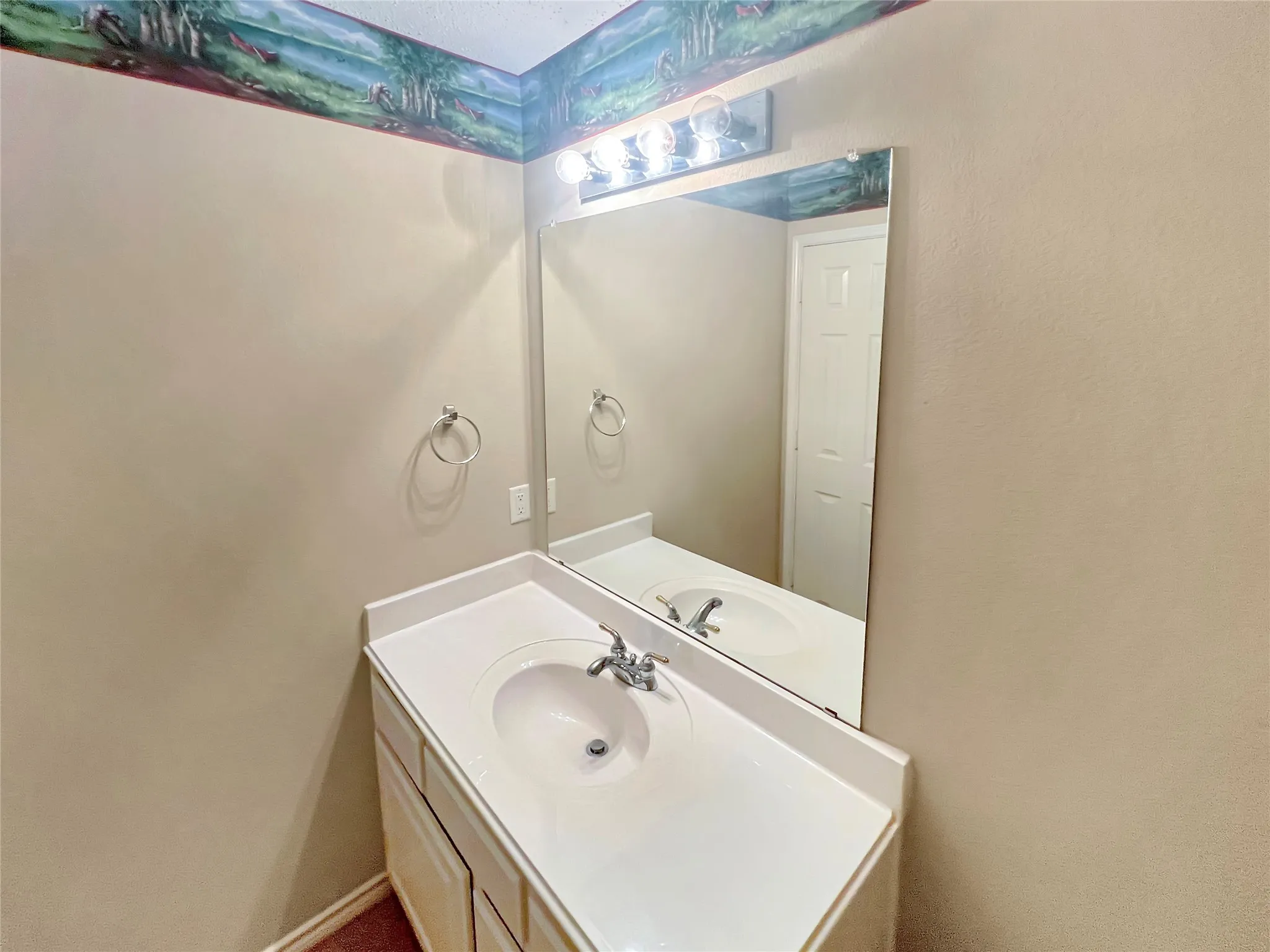 White vanity with an integrated sink, polished chrome faucet, and a large wall-mounted mirror